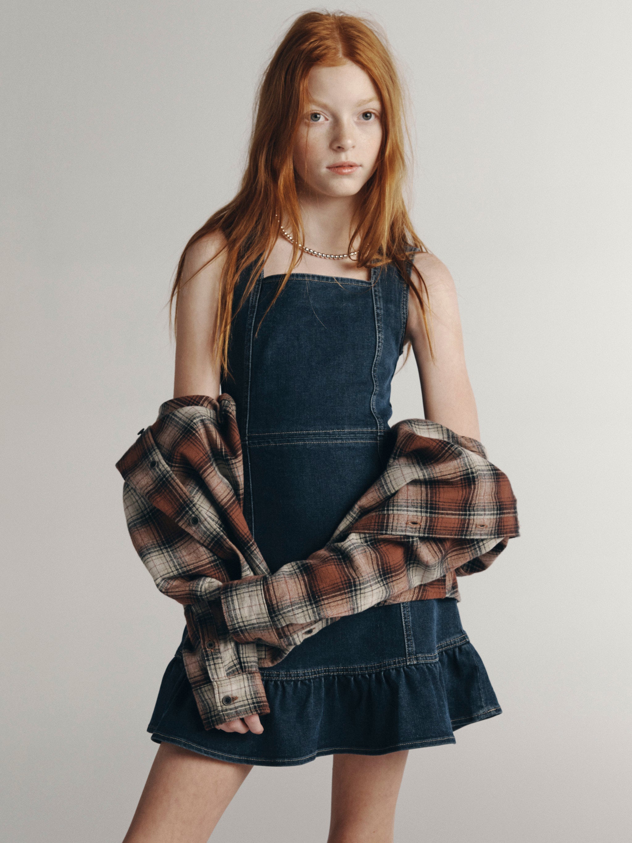 DL1961 Kids girls' Bety square neck dress in Nightlight styled with a plaid flannel, front three-quarter view in a studio.
