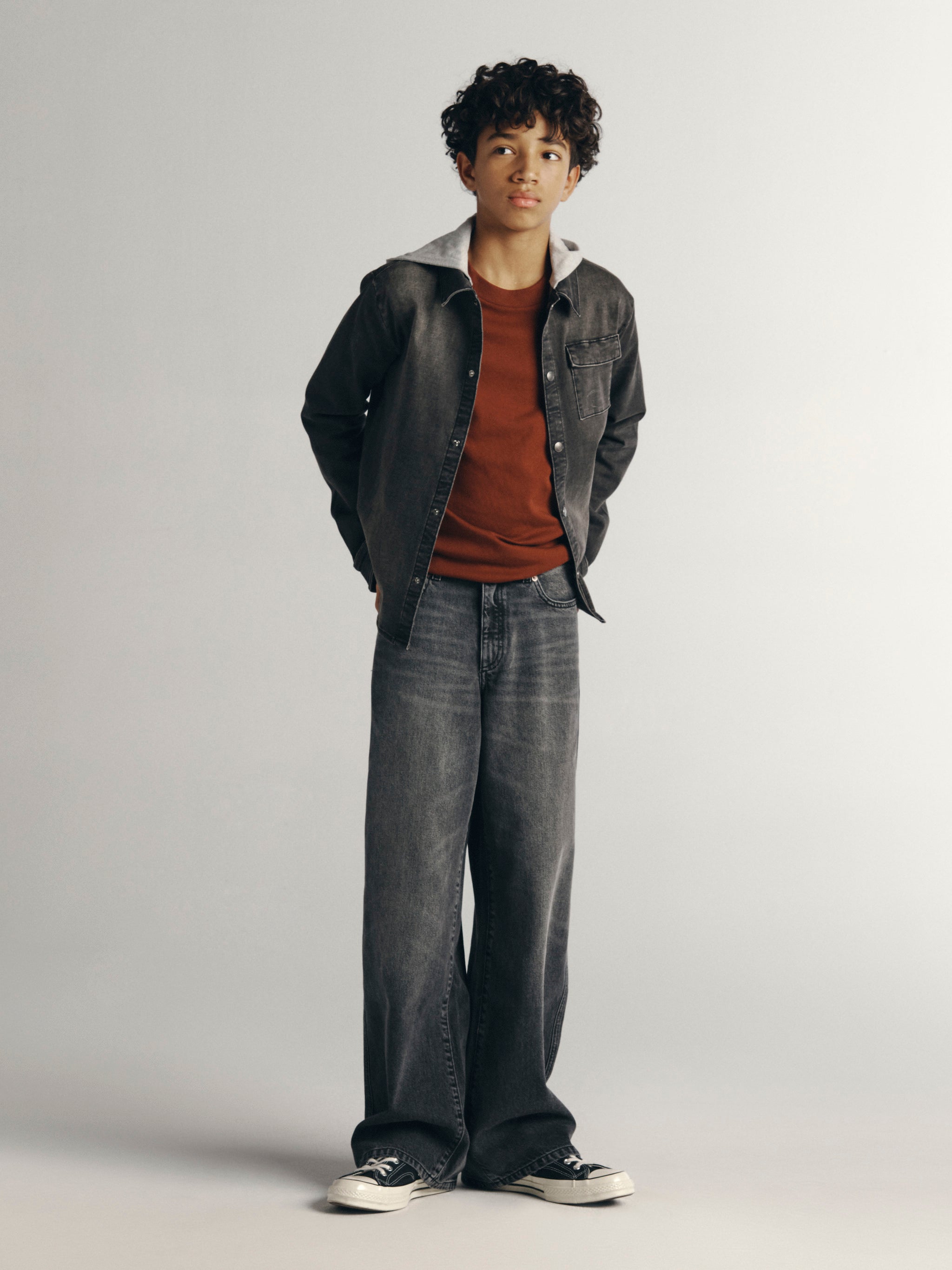 DL1961 Kids boys' Mason wide-leg jeans in Nightshade with a grey Matteo hooded shirt and rust tee, full-length front, studio.
