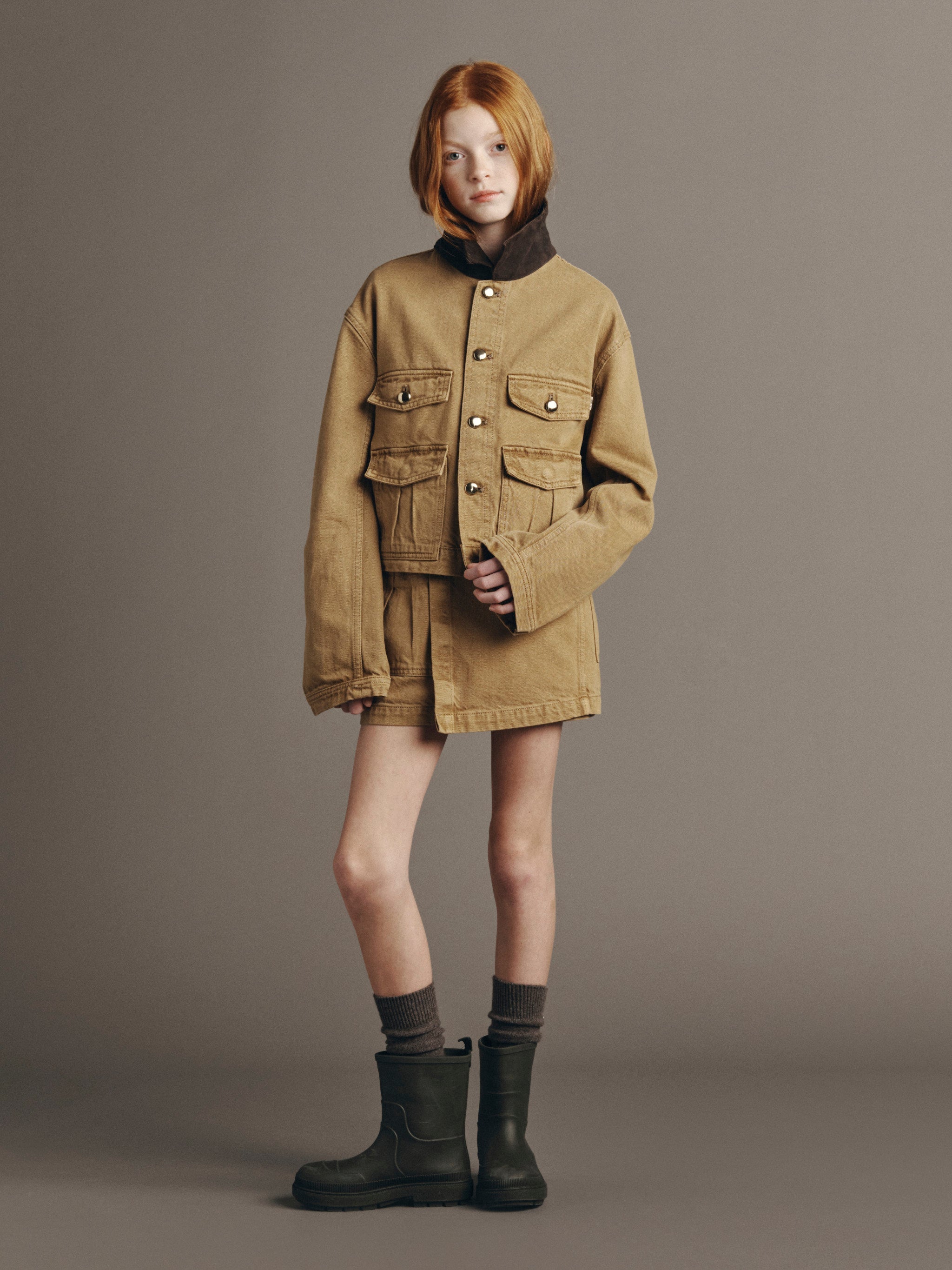 DL1961 Kids girls' Selina skirt in Savannas with a matching Reese utility jacket, full-length front view in a studio.