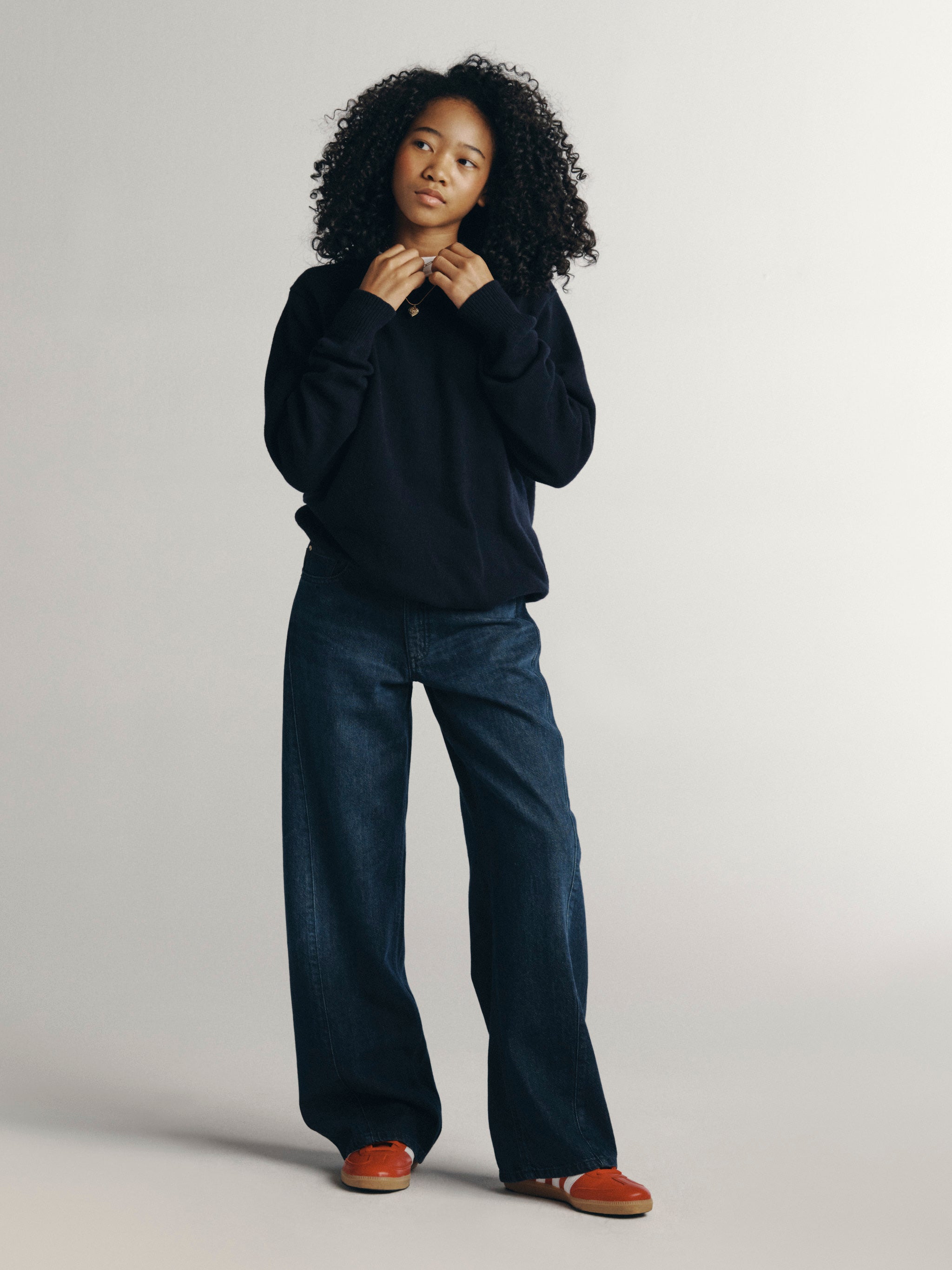 DL1961 Kids girls' Frankie low-slung jeans in Deep Water with a navy sweater, full-length front view in a studio.