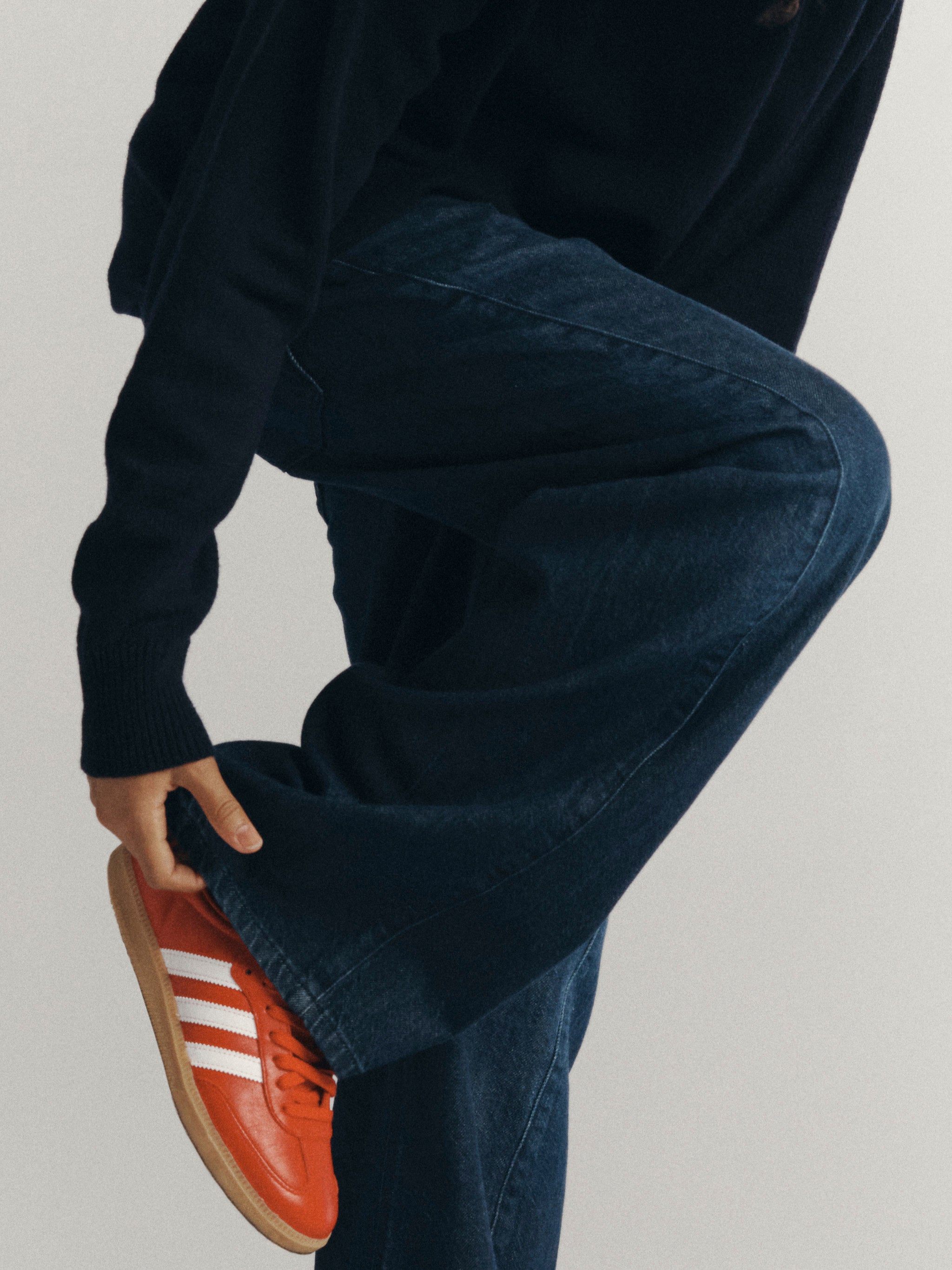DL1961 Kids girls' Frankie low-slung jeans in Deep Water, close-up of the hem styled with red sneakers.