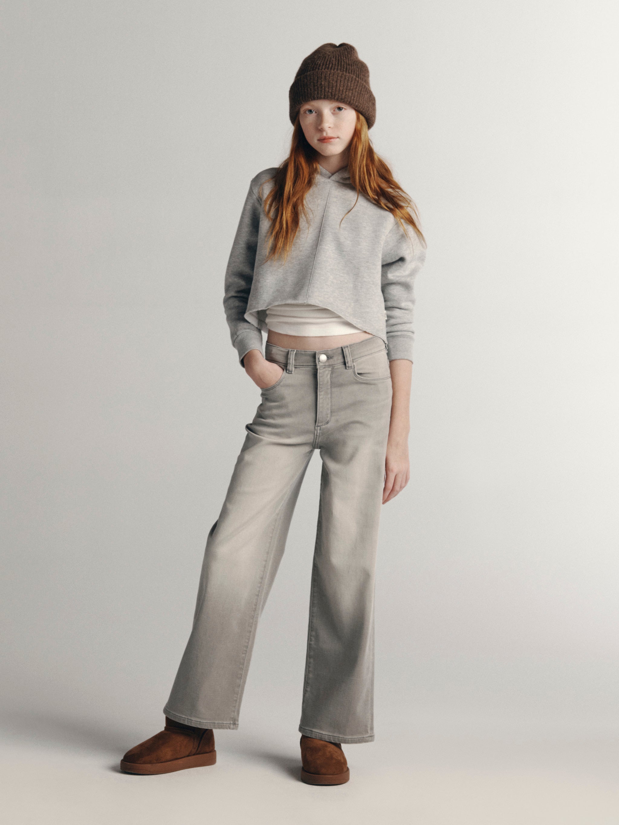 DL1961 Kids girls' Lily wide-leg jeans in Washed Grey Knit with a grey hoodie and brown beanie, full-length front, studio.
