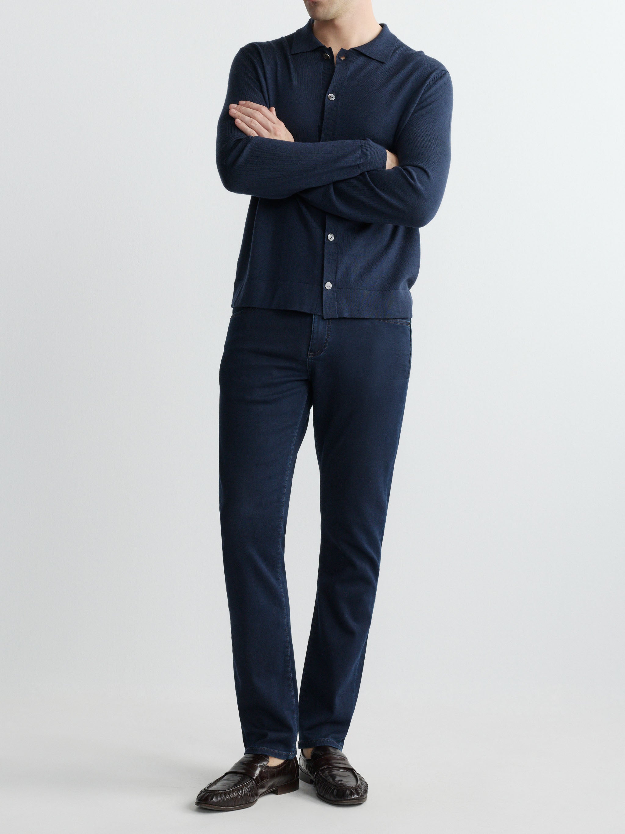 Person wearing a navy blue outfit with a shirt and pants on a white background