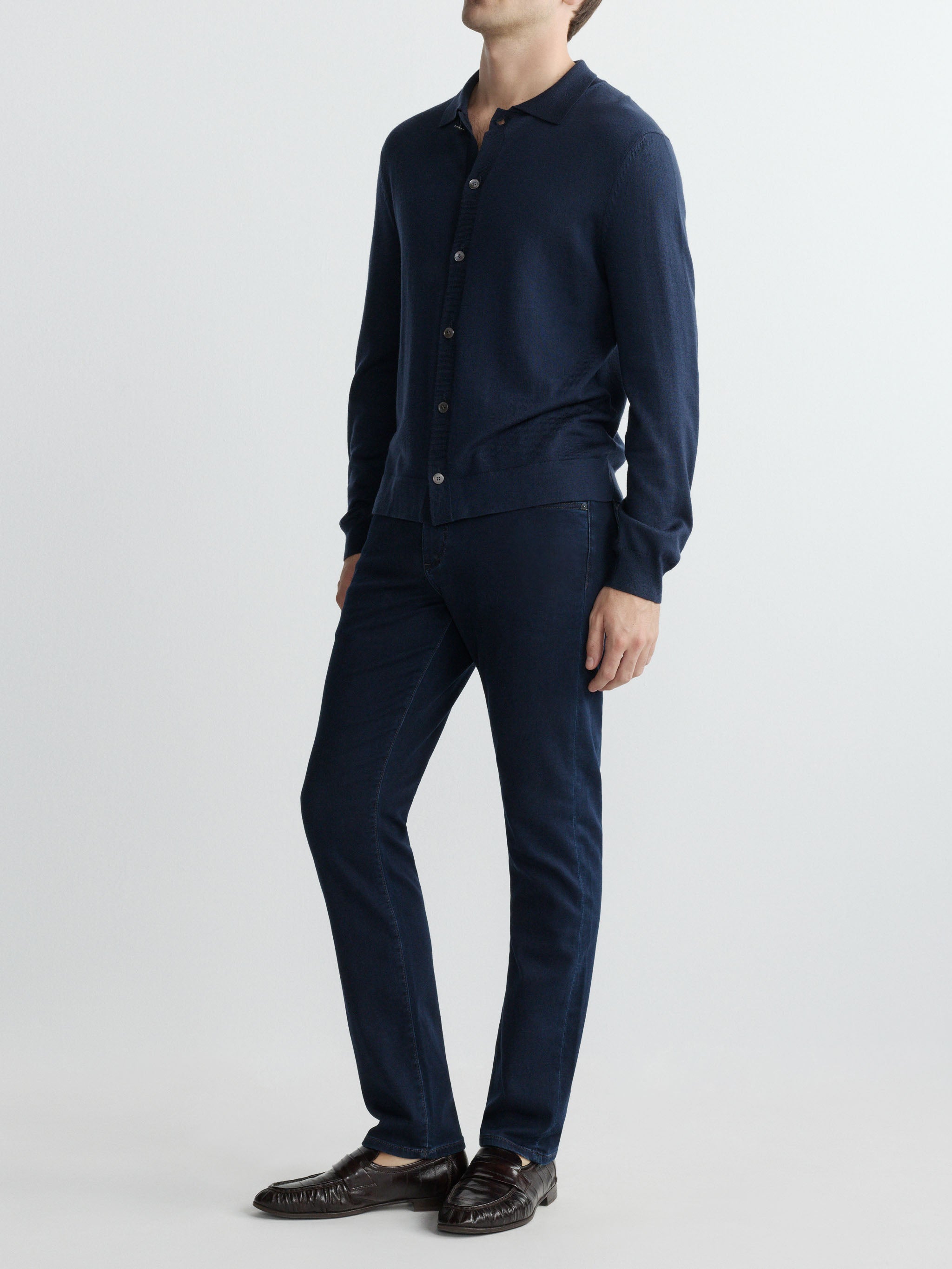 Man wearing a navy blue shirt and pants on a white background