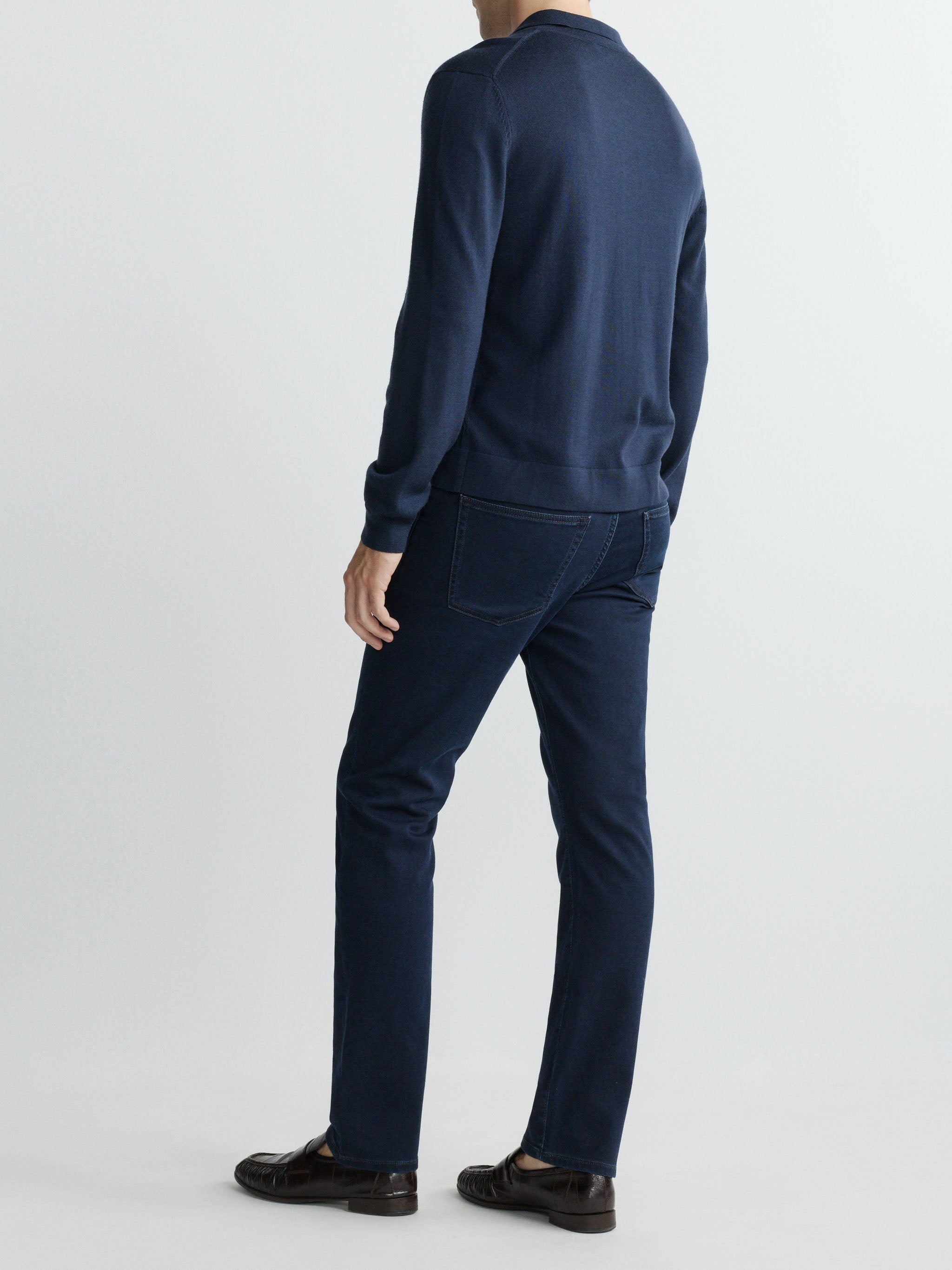 Person wearing a navy blue sweater and pants on a white background
