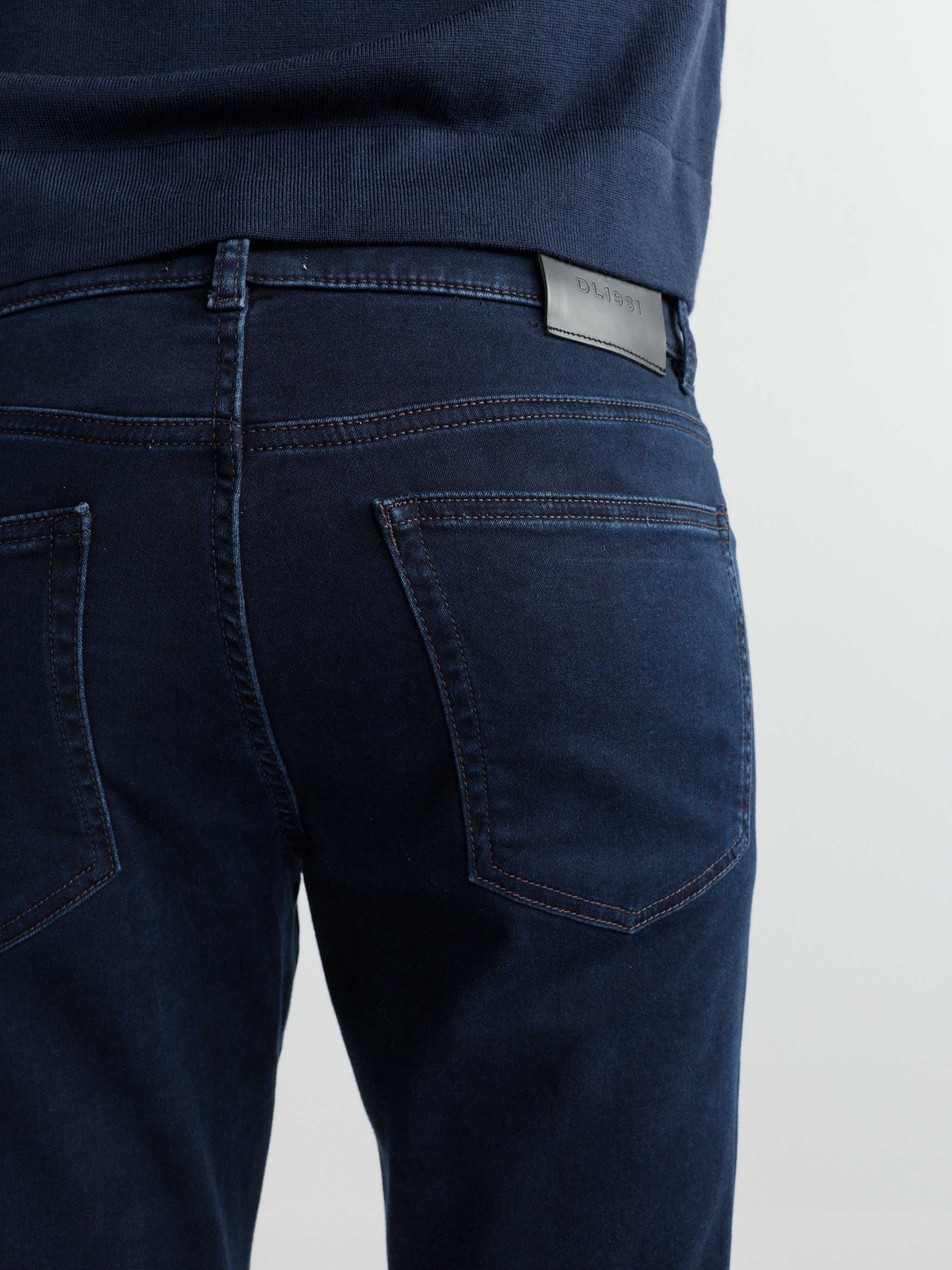 Dark blue jeans with a visible brand label on a light gray background