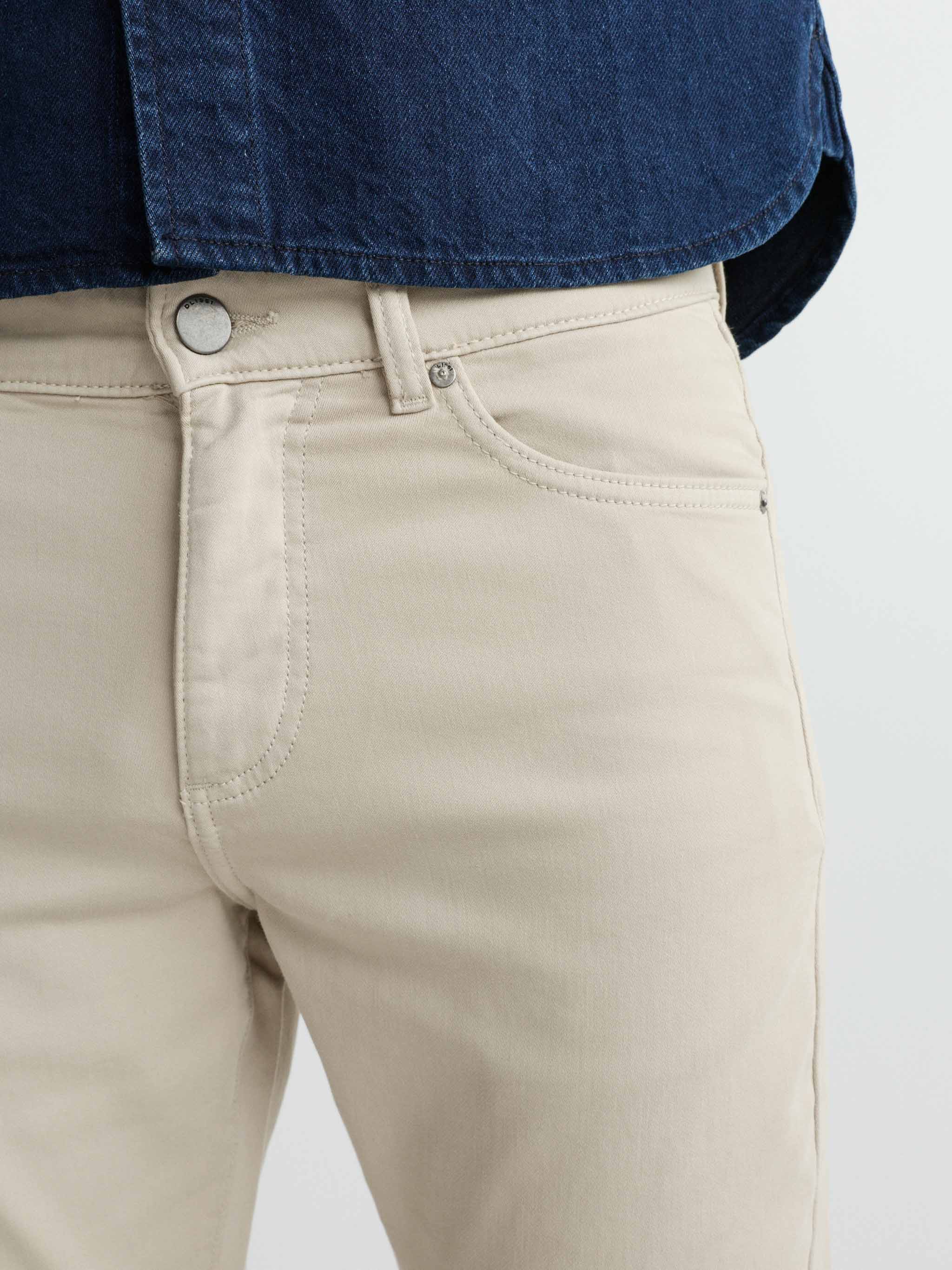Beige pants with a blue shirt on a white background