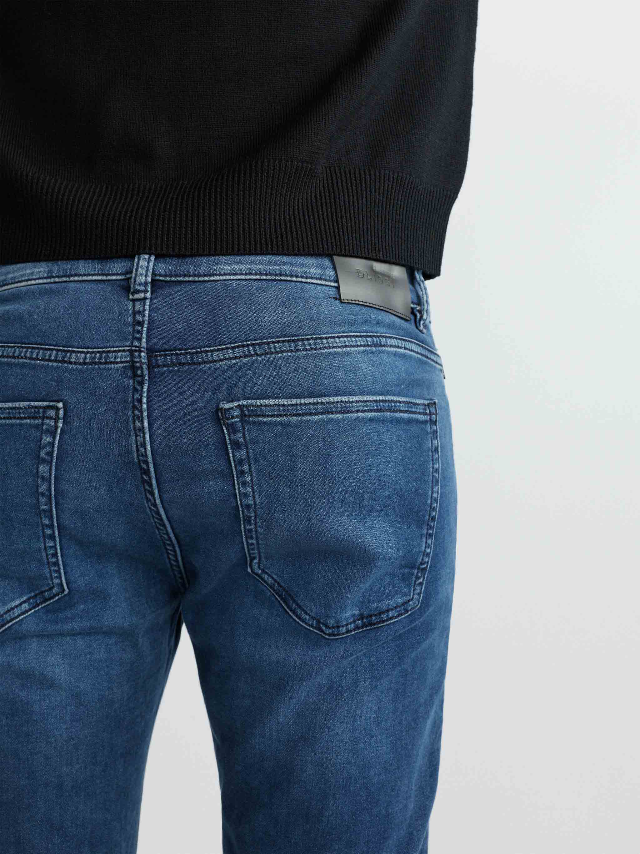 Blue jeans worn by a person on a white background