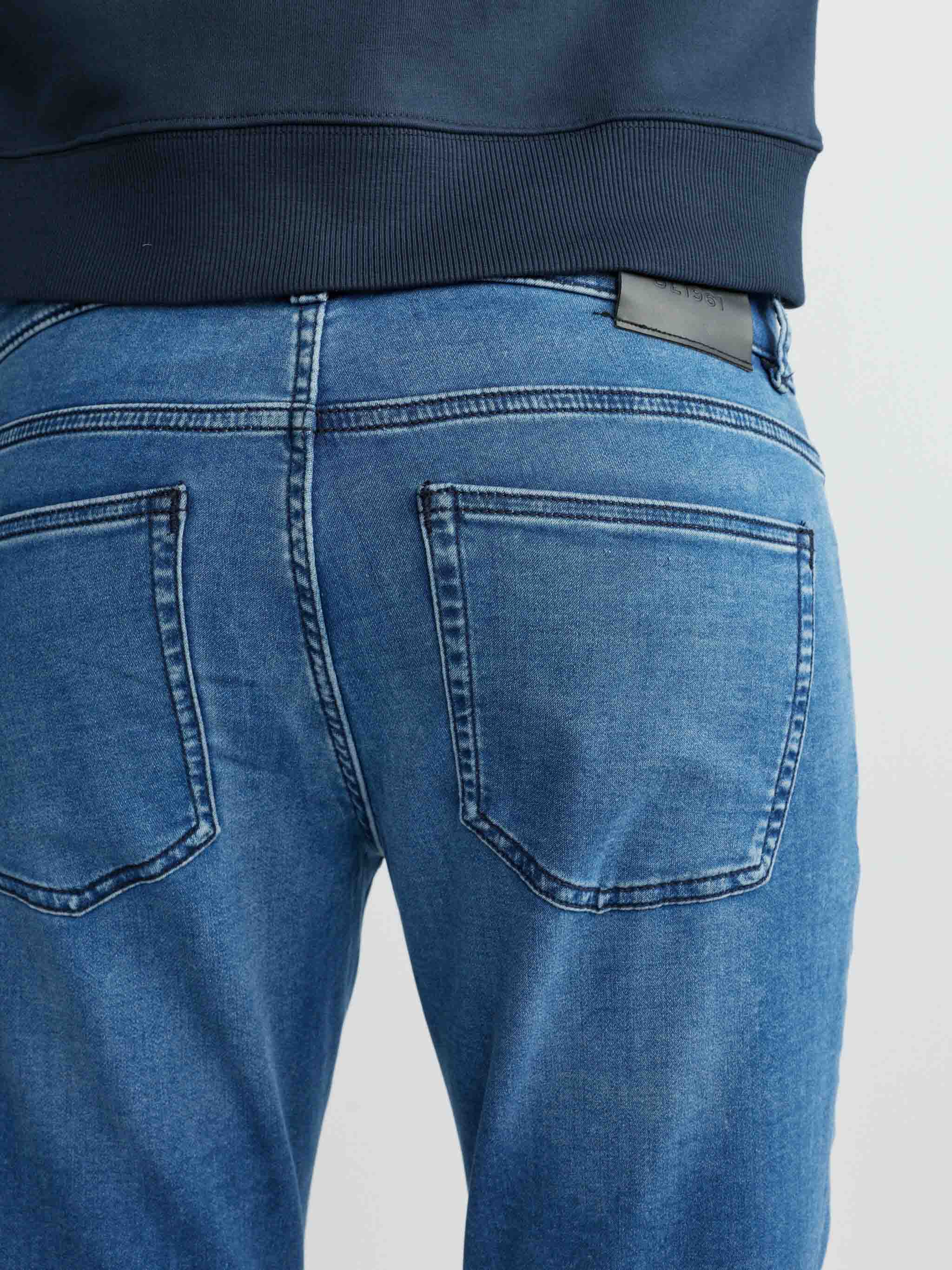 Blue jeans worn by a person on a light gray background