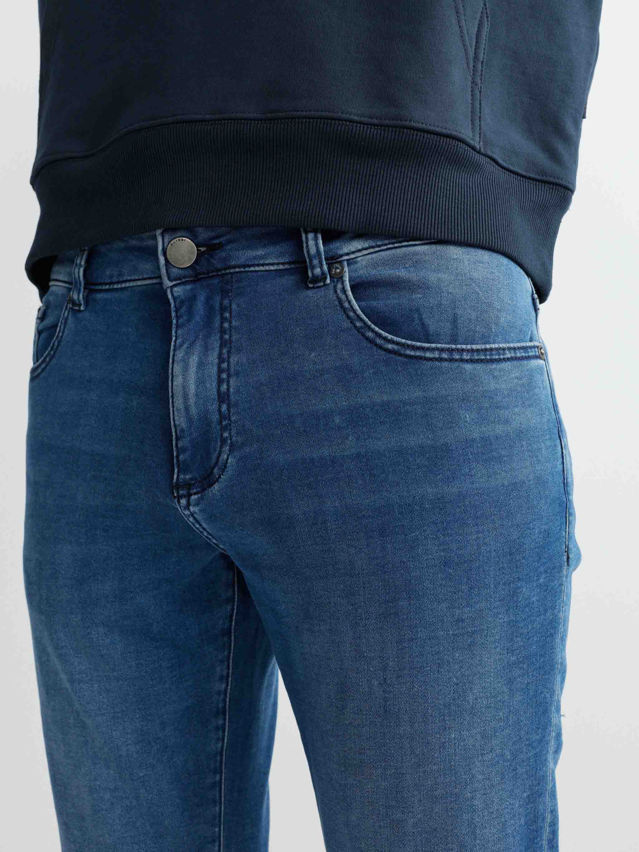 Blue jeans worn by a person on a light gray background