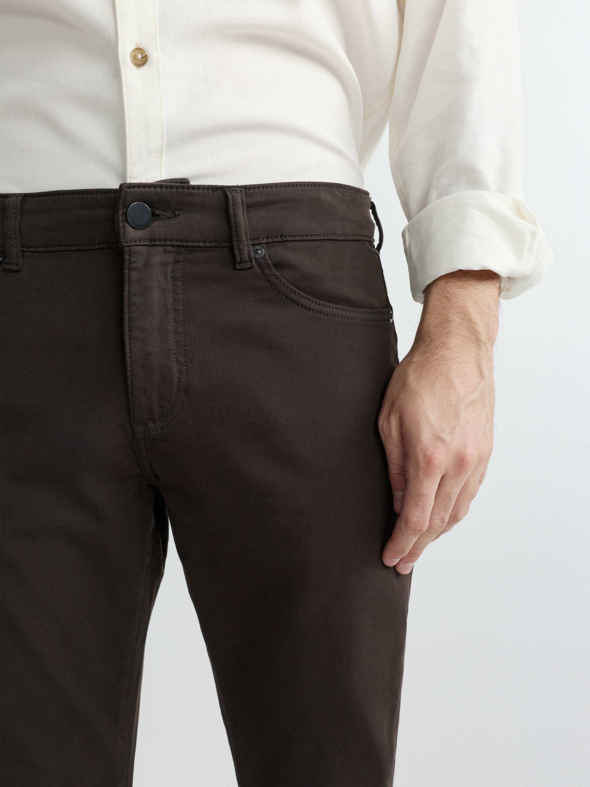 Person wearing dark pants and a white shirt on a light gray background