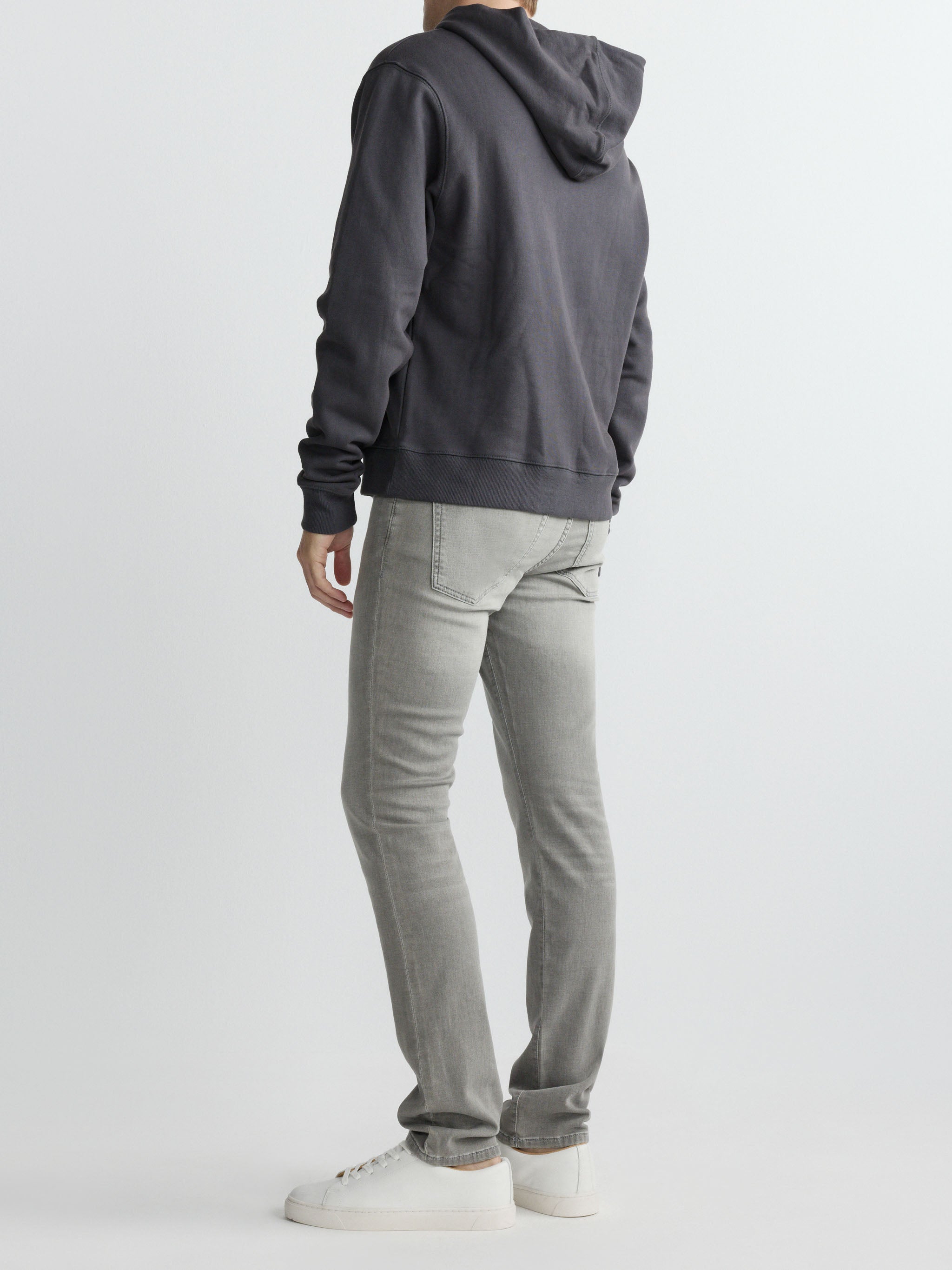 Person wearing a gray hoodie and pants on a white background