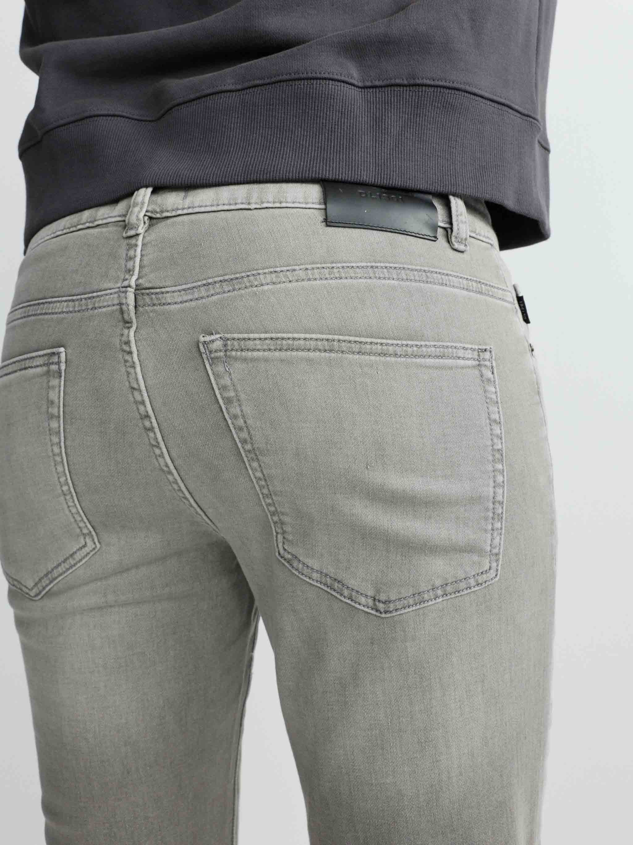 Gray jeans worn by a person on a light gray background
