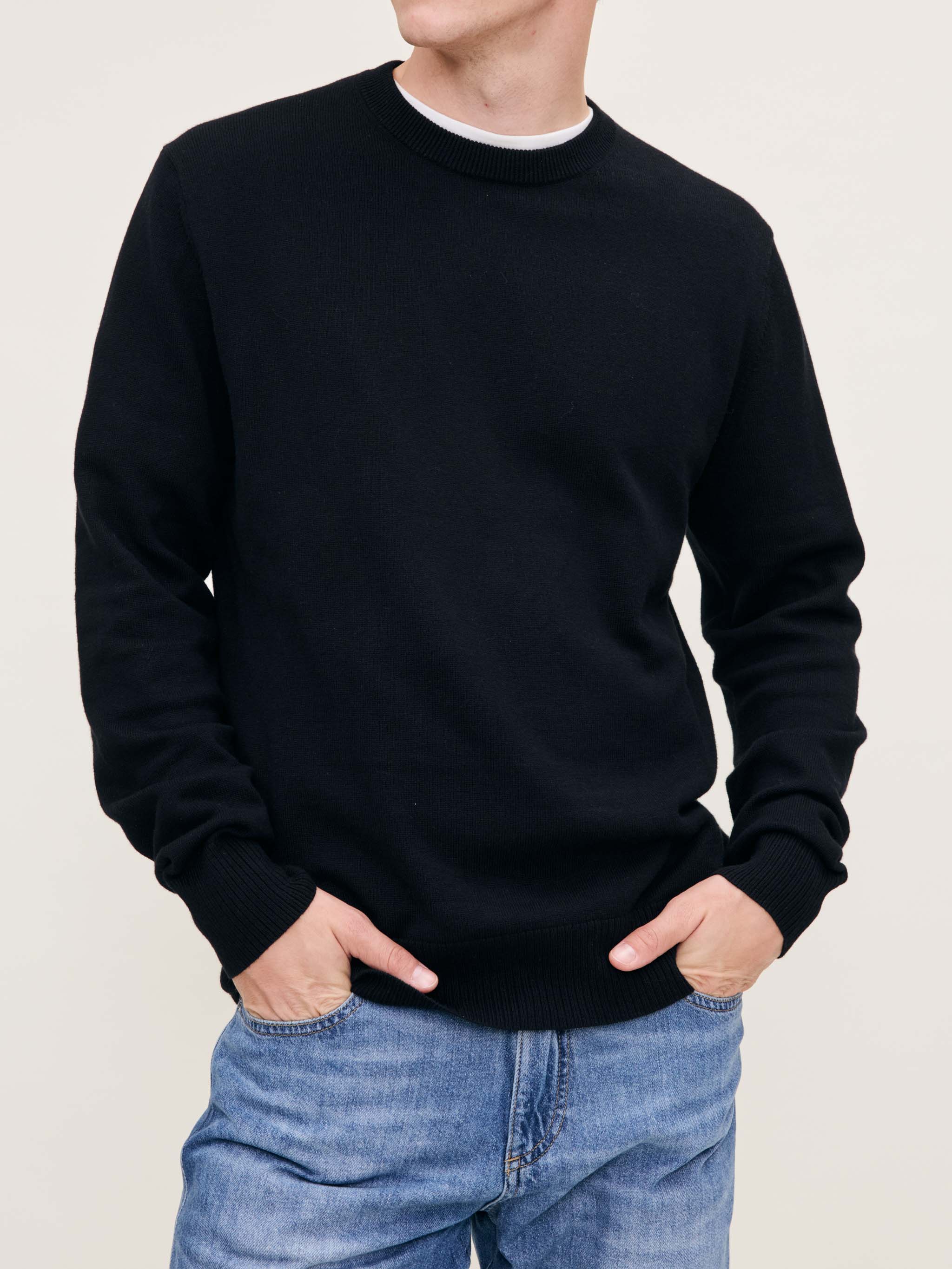 DL1961 men's Classic Crewneck sweater in black, front view on model with hands in jean pockets.