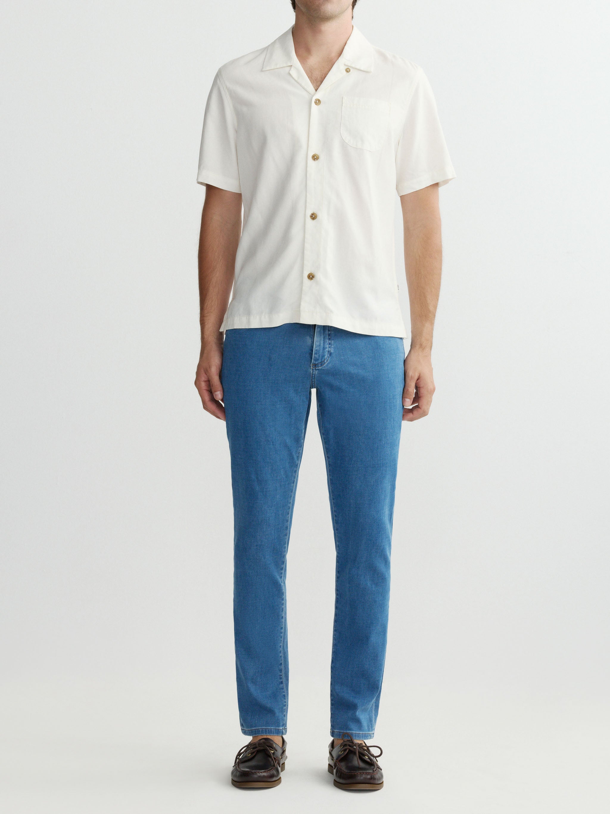 Person wearing a white shirt and blue jeans on a white background