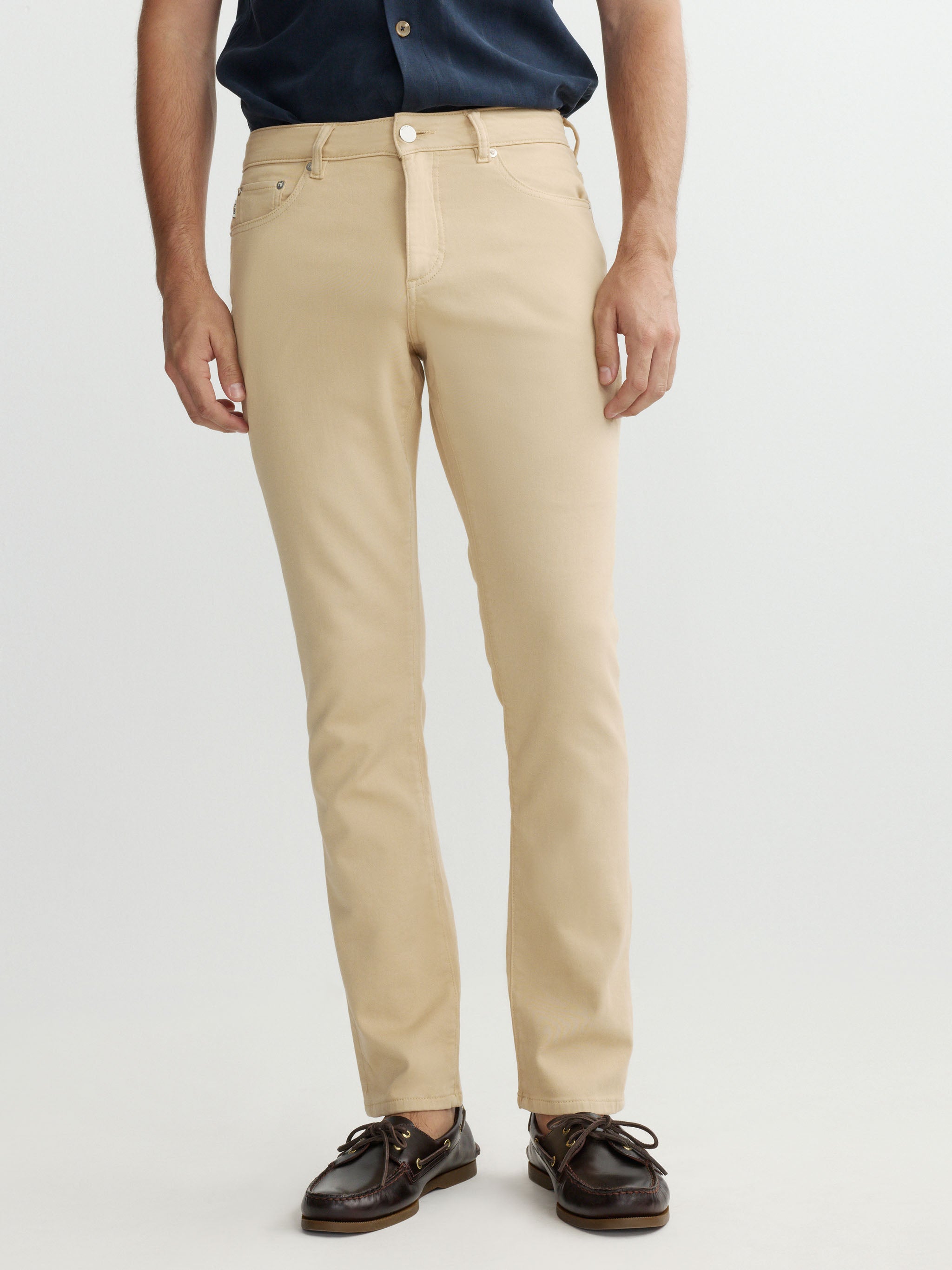 Person wearing beige pants on a white background