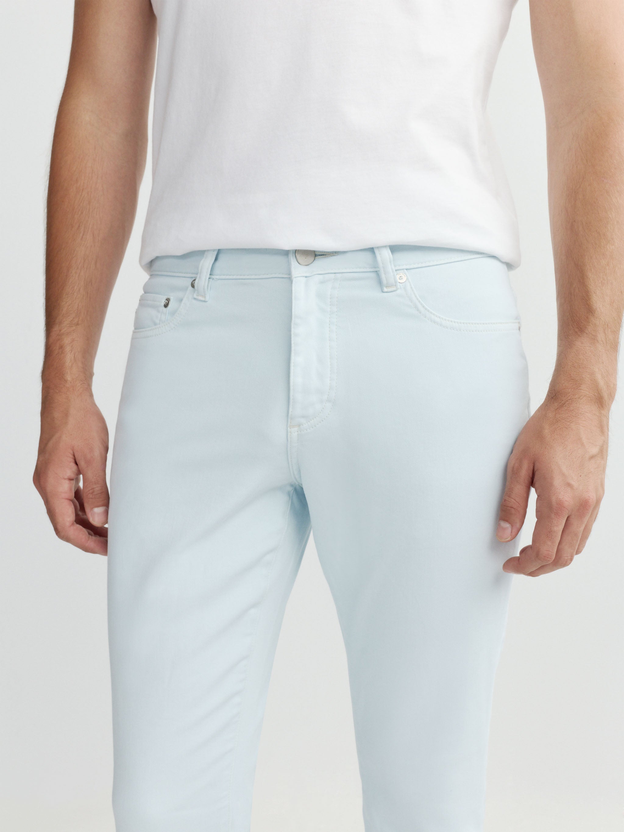 Light blue jeans worn by a person on a white background