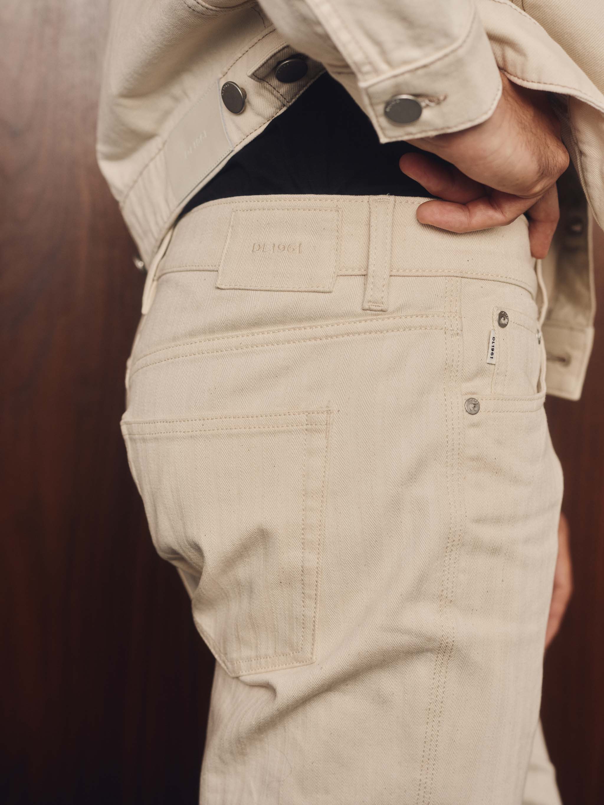 Person wearing a beige pants on a wood background