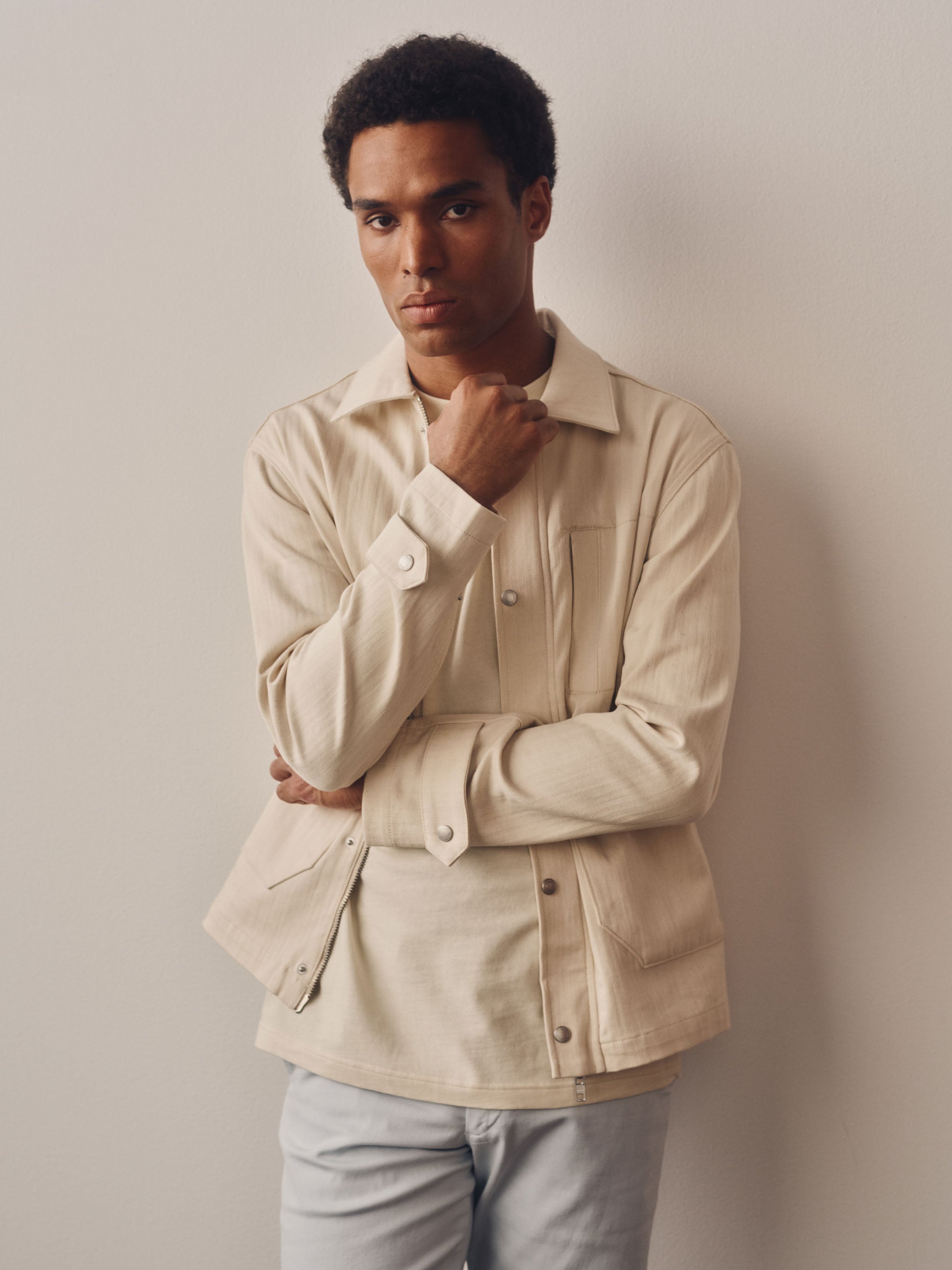 Man wearing a beige jacket against a plain background