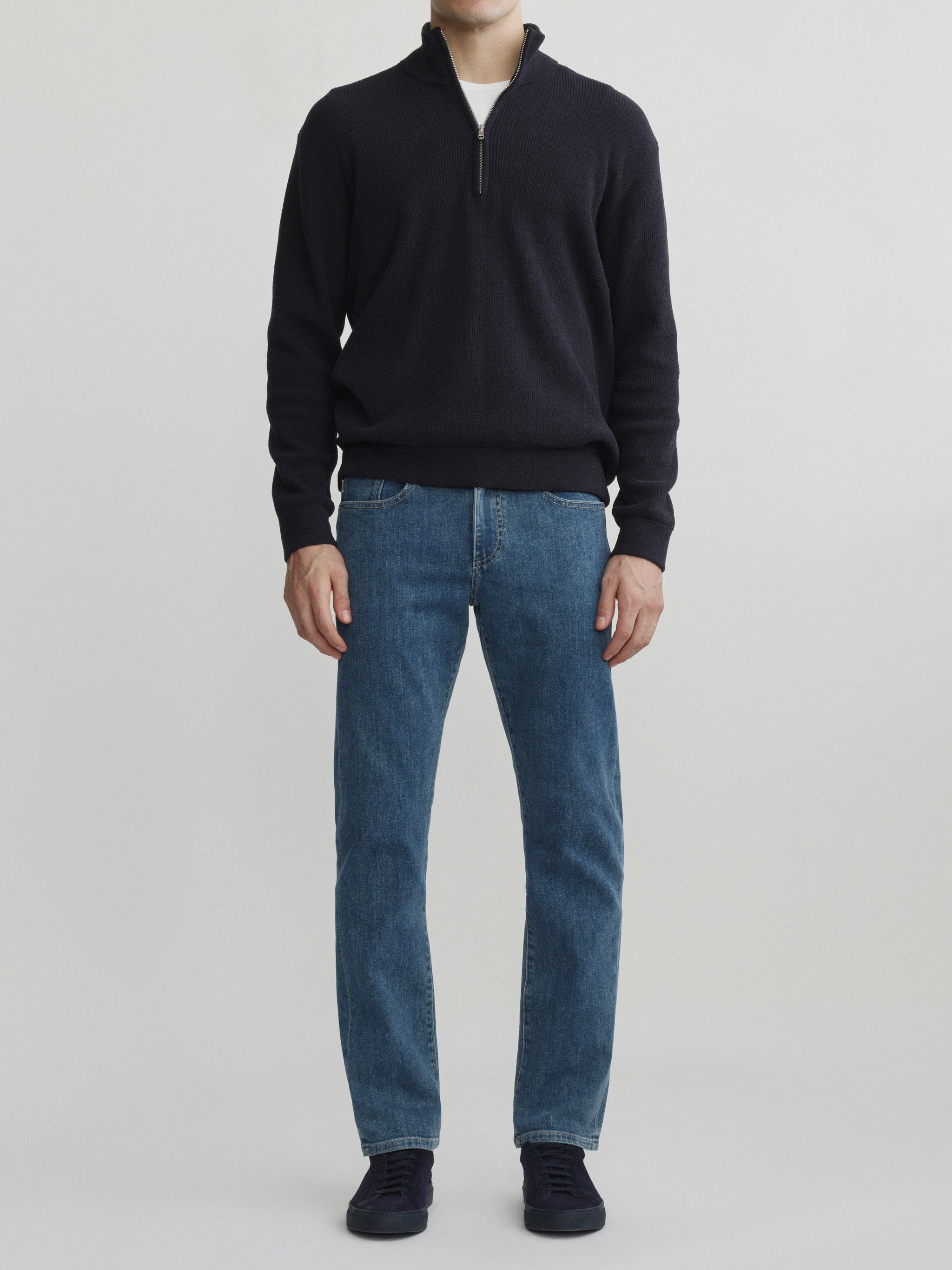 DL1961 men's Russell Slim Straight jeans in medium blue 'Highland Park', full-length front view with a navy quarter-zip sweater.