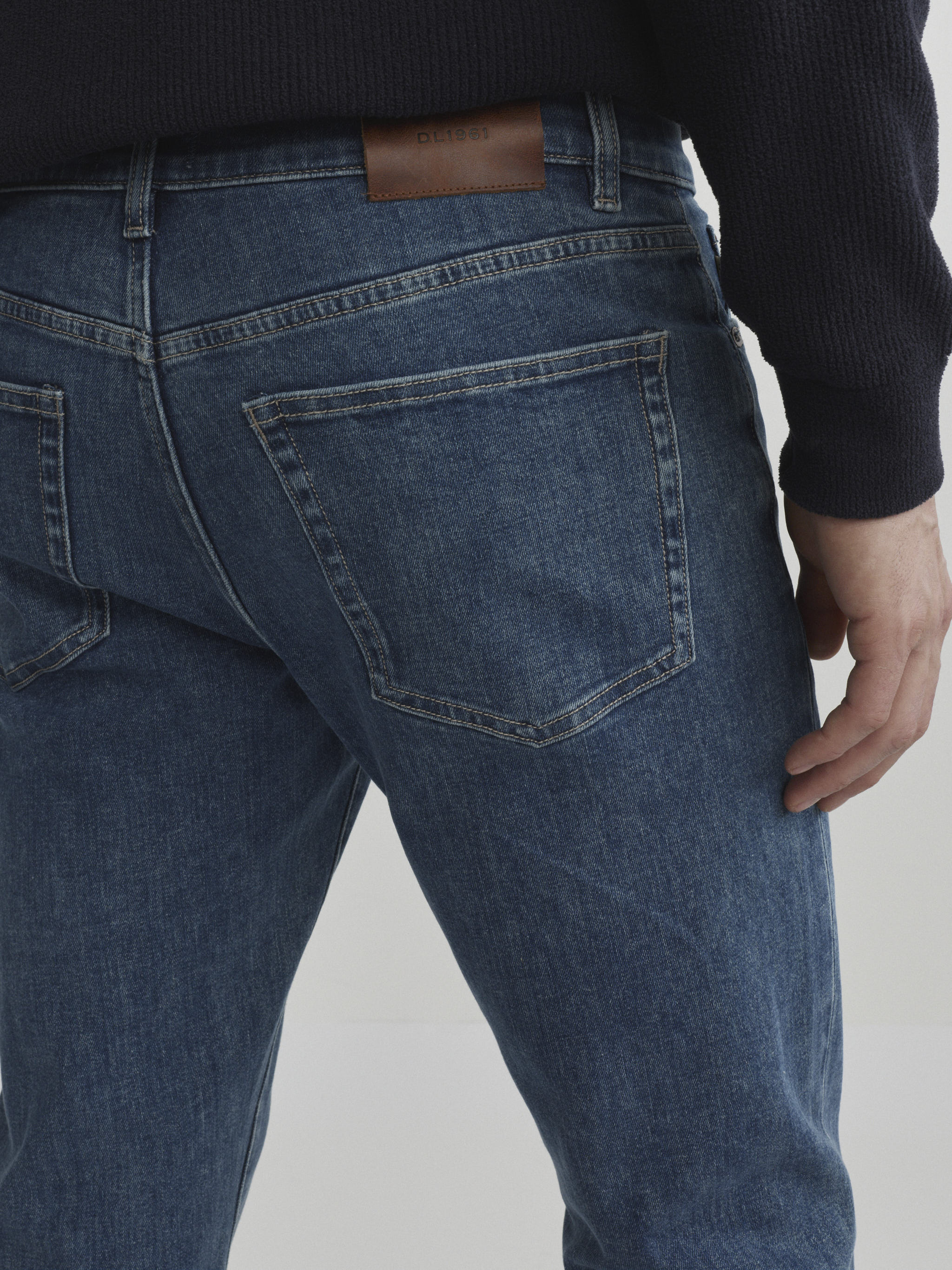 DL1961 men's Russell Slim Straight jeans in medium blue 'Highland Park', close-up of the back pocket and leather patch.