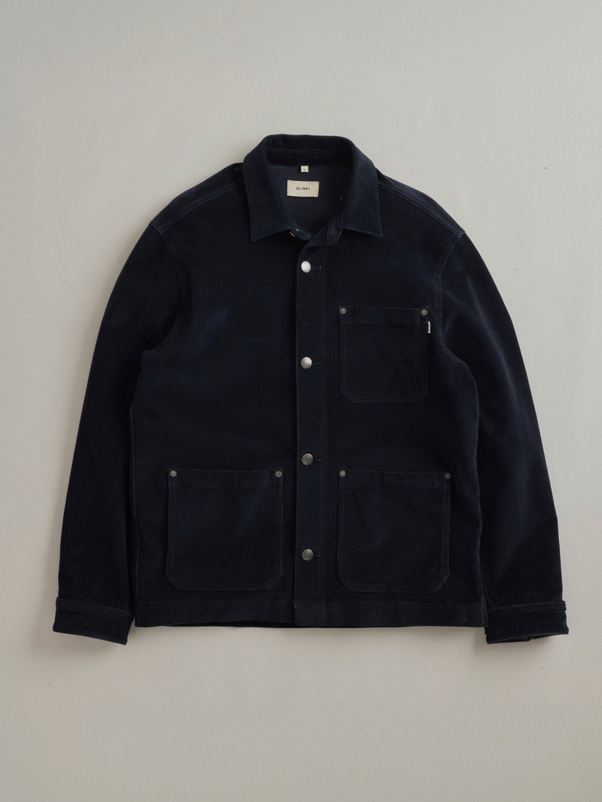 DL1961 men's Sean corduroy shirt jacket in navy 'Skyline', flat lay front view with snap placket and three patch pockets.
