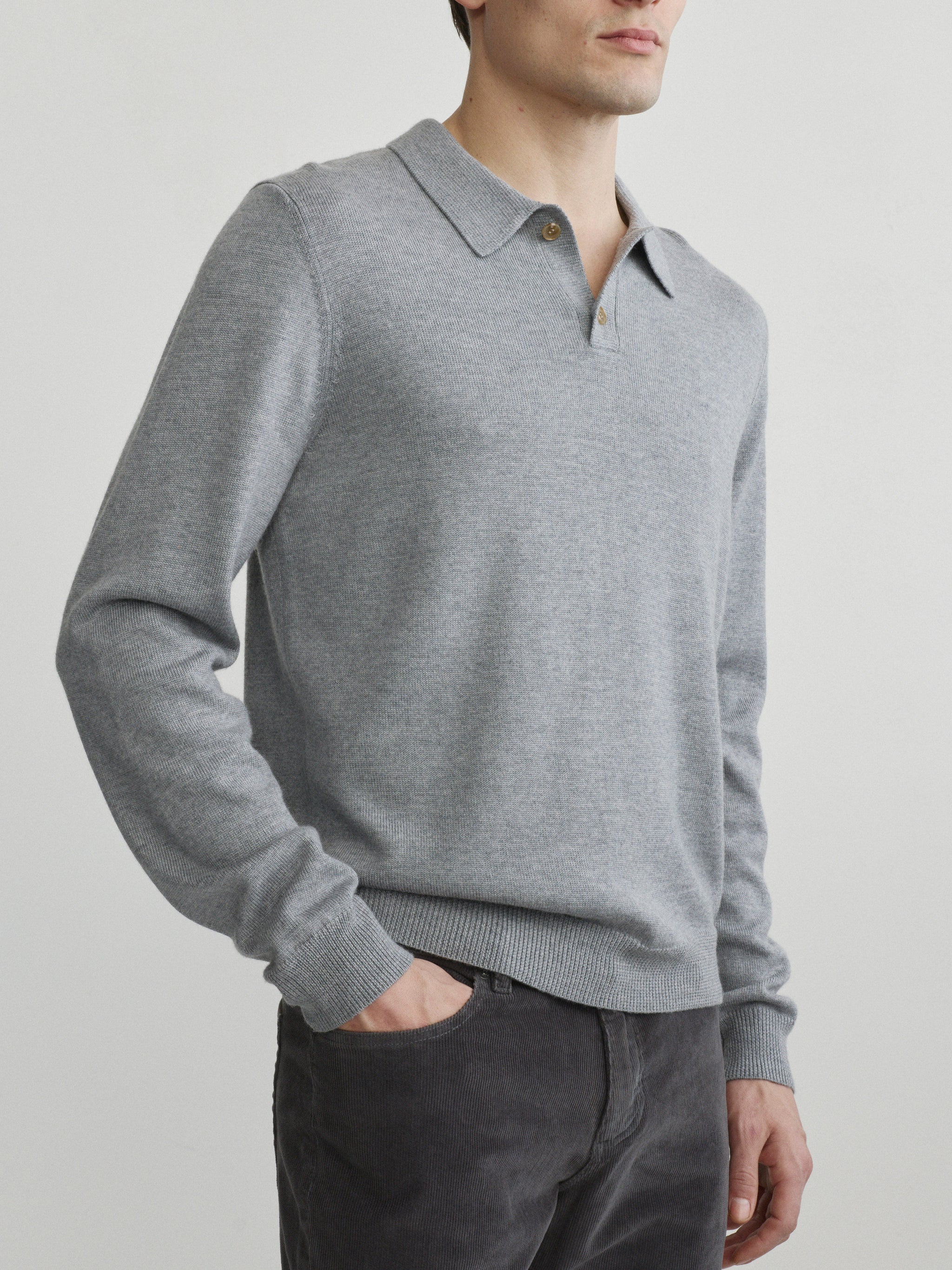 DL1961 men's long-sleeve knit polo in grey melange, three-quarter front with charcoal corduroy pants