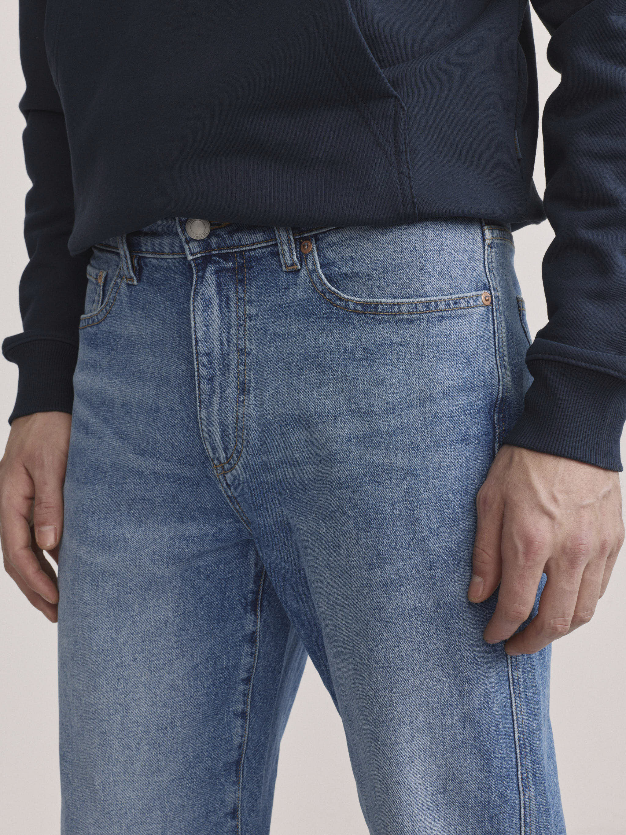 DL1961 men's Chris modern straight jeans in light blue 'Stonecut', close-up of front waist, button fly and pockets.