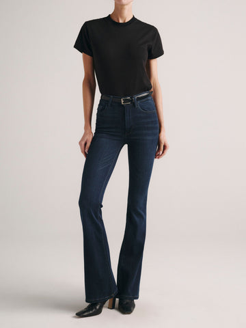 Bridget Boot jeans in Dark Indigo on a model in a black tee, full-length front angle in a studio.