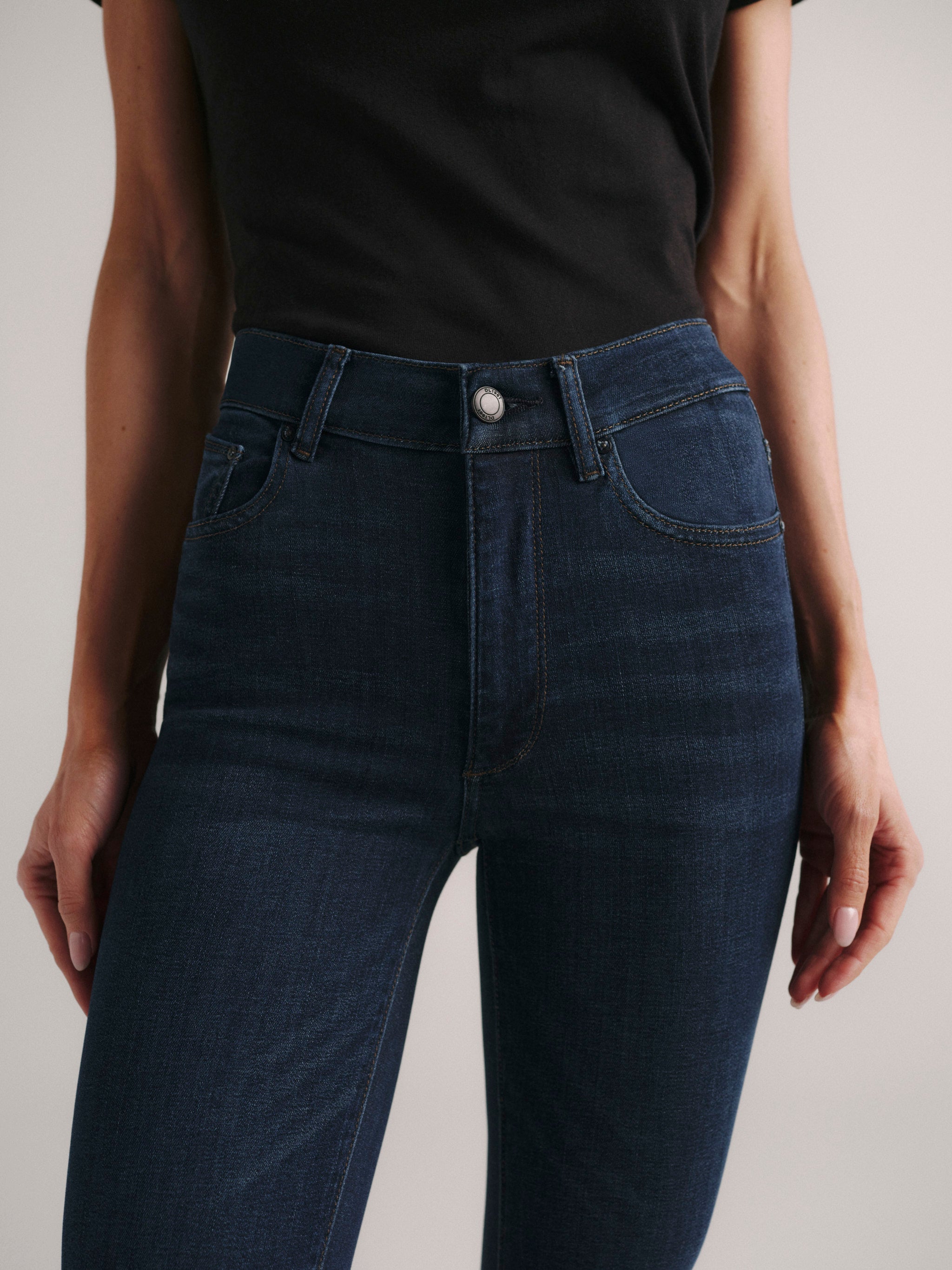 Bridget Boot jeans in Dark Indigo, close-up of the high-rise waist and front pockets on a model.