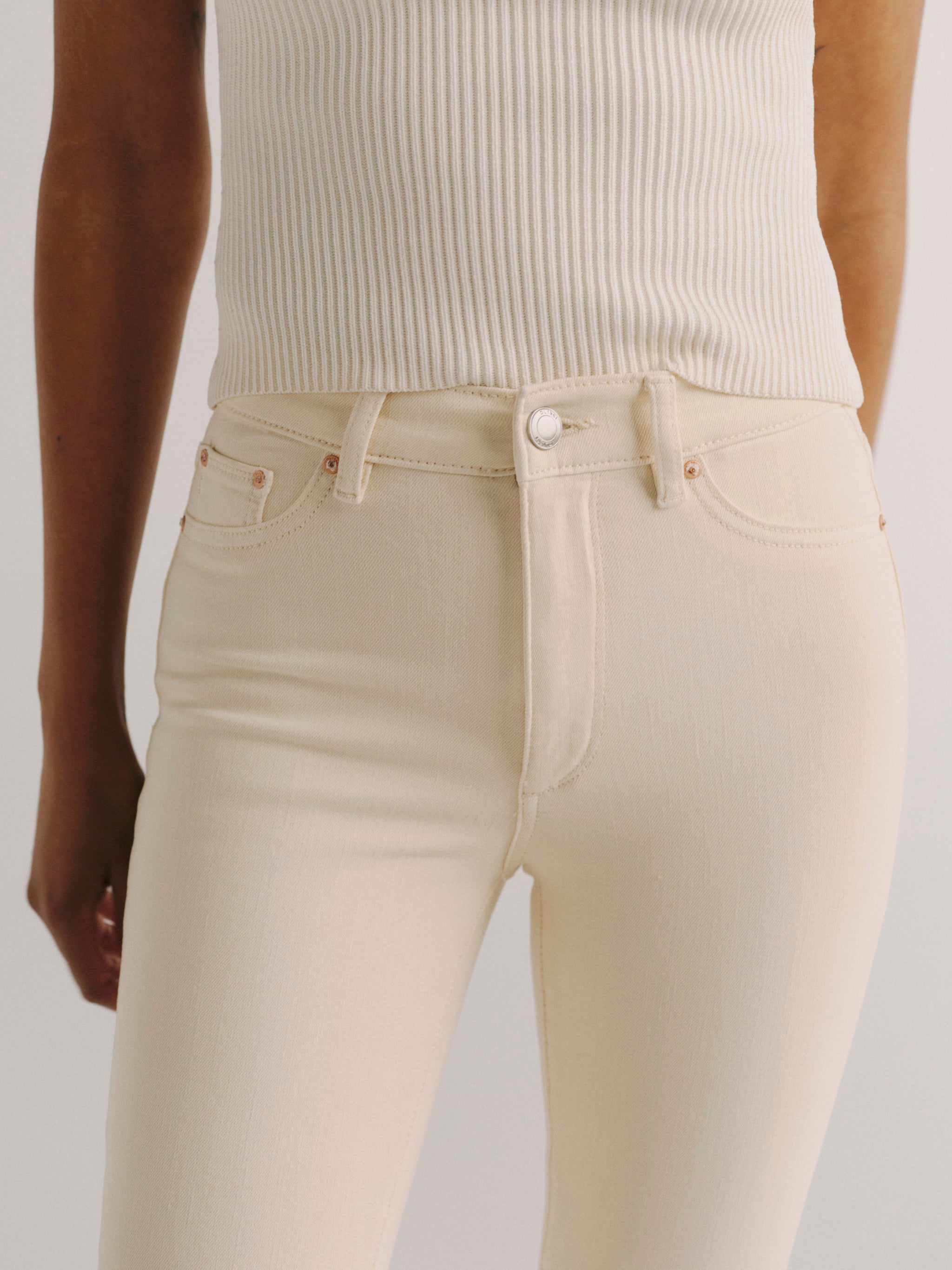 DL1961 women's Bridget Boot High Rise Instasculpt crop jeans in ivory 'Flax', back view showing the rear pockets and cropped leg.