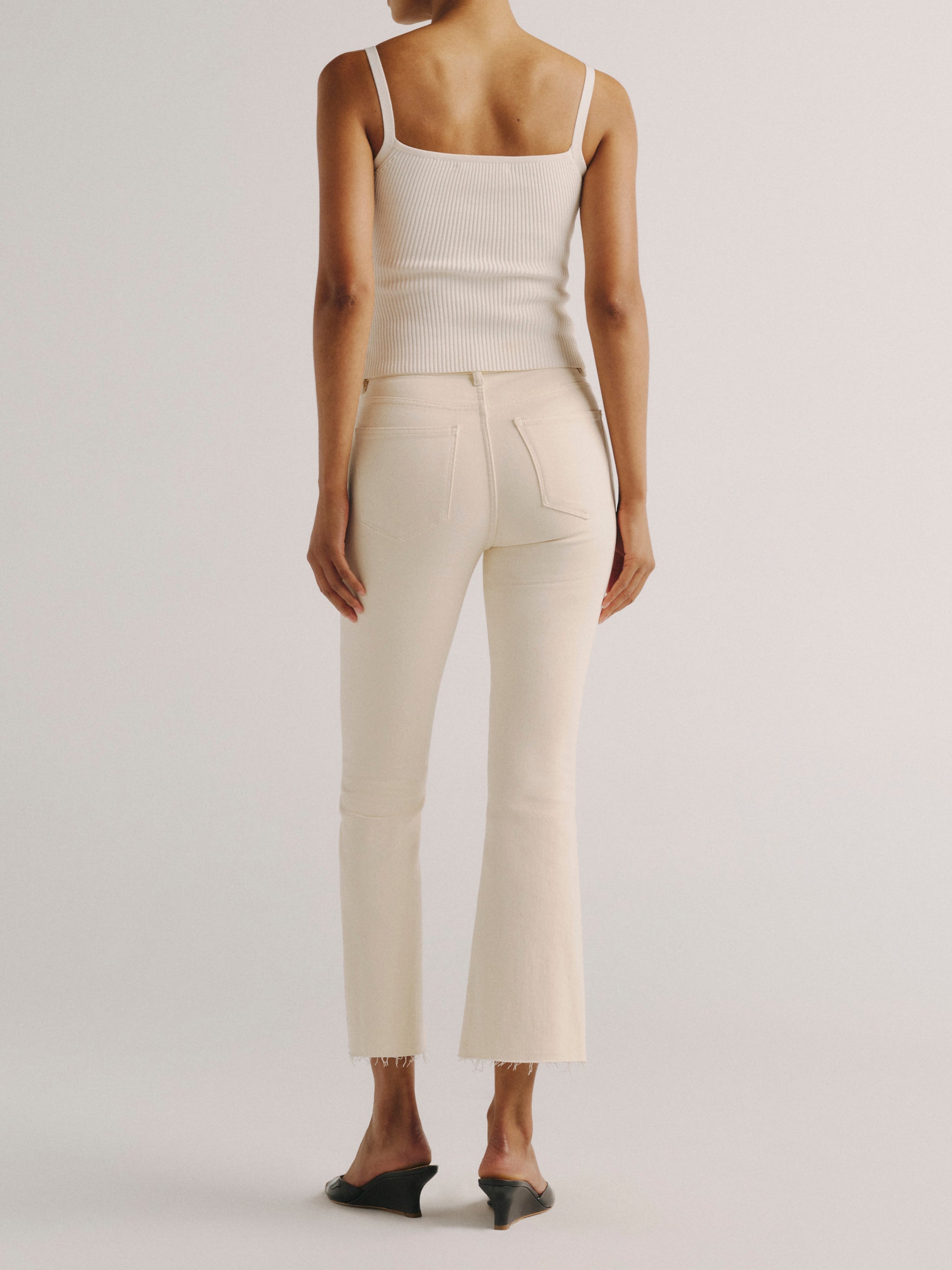 DL1961 women's Bridget Boot High Rise Instasculpt crop jeans in ivory 'Flax', close-up of the high rise waist, button and front pocket.