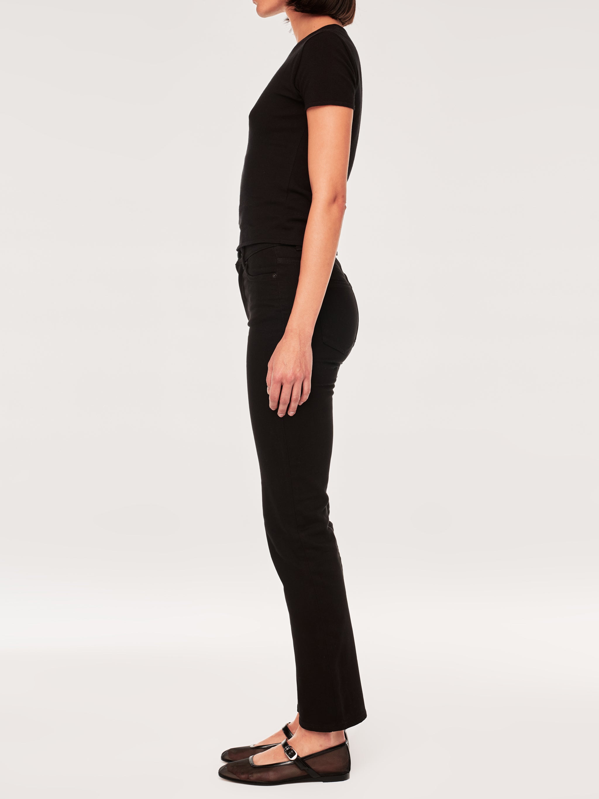 Halle jeans in Black Peach on a model in a black tee, full-length side profile in a studio.