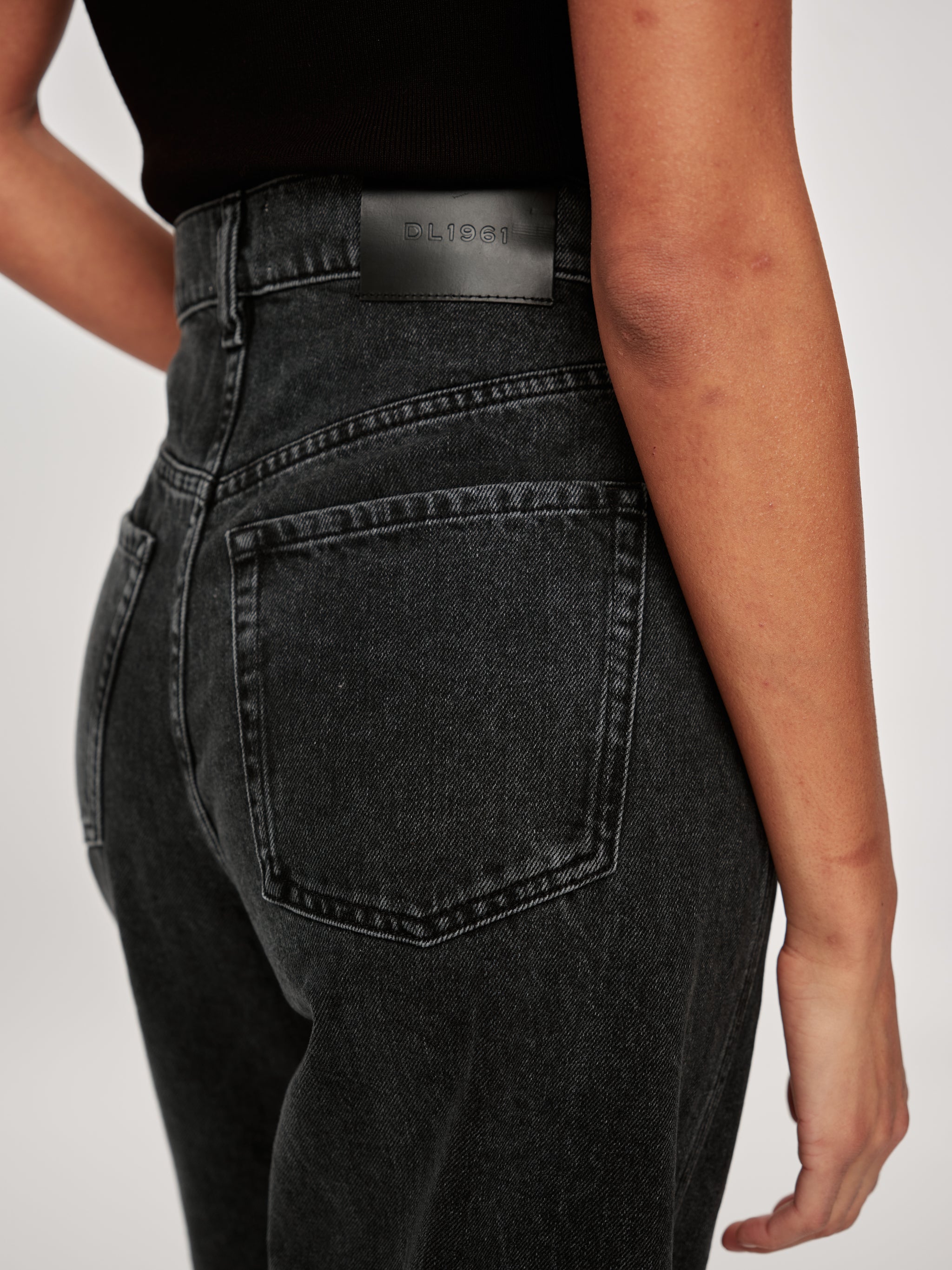 Taylor jeans in Nightshade, close-up of the high-rise waist and back pocket on a model.