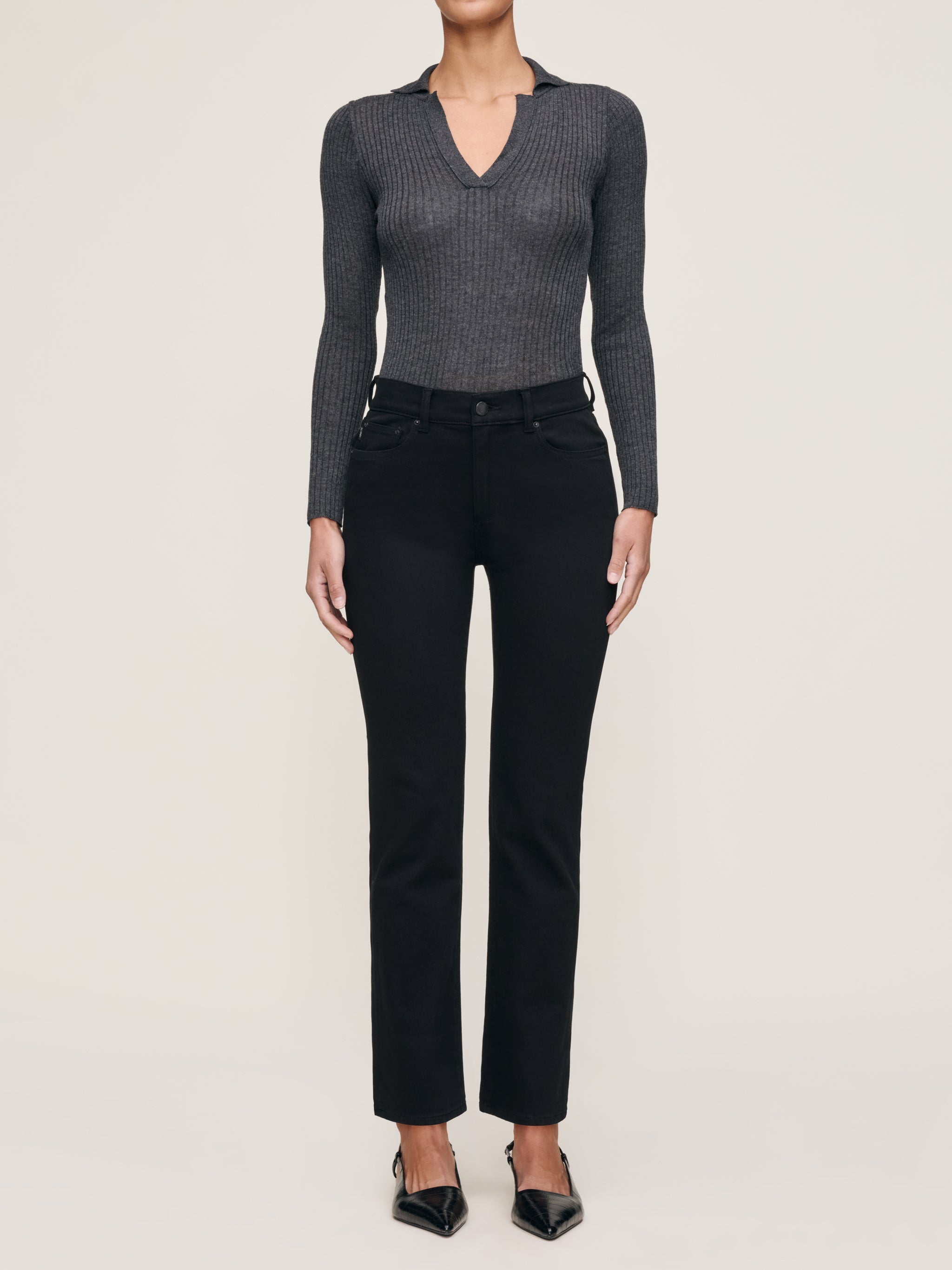 Mara jeans in Black on a model in a grey knit polo, full-length front view with pointed flats.