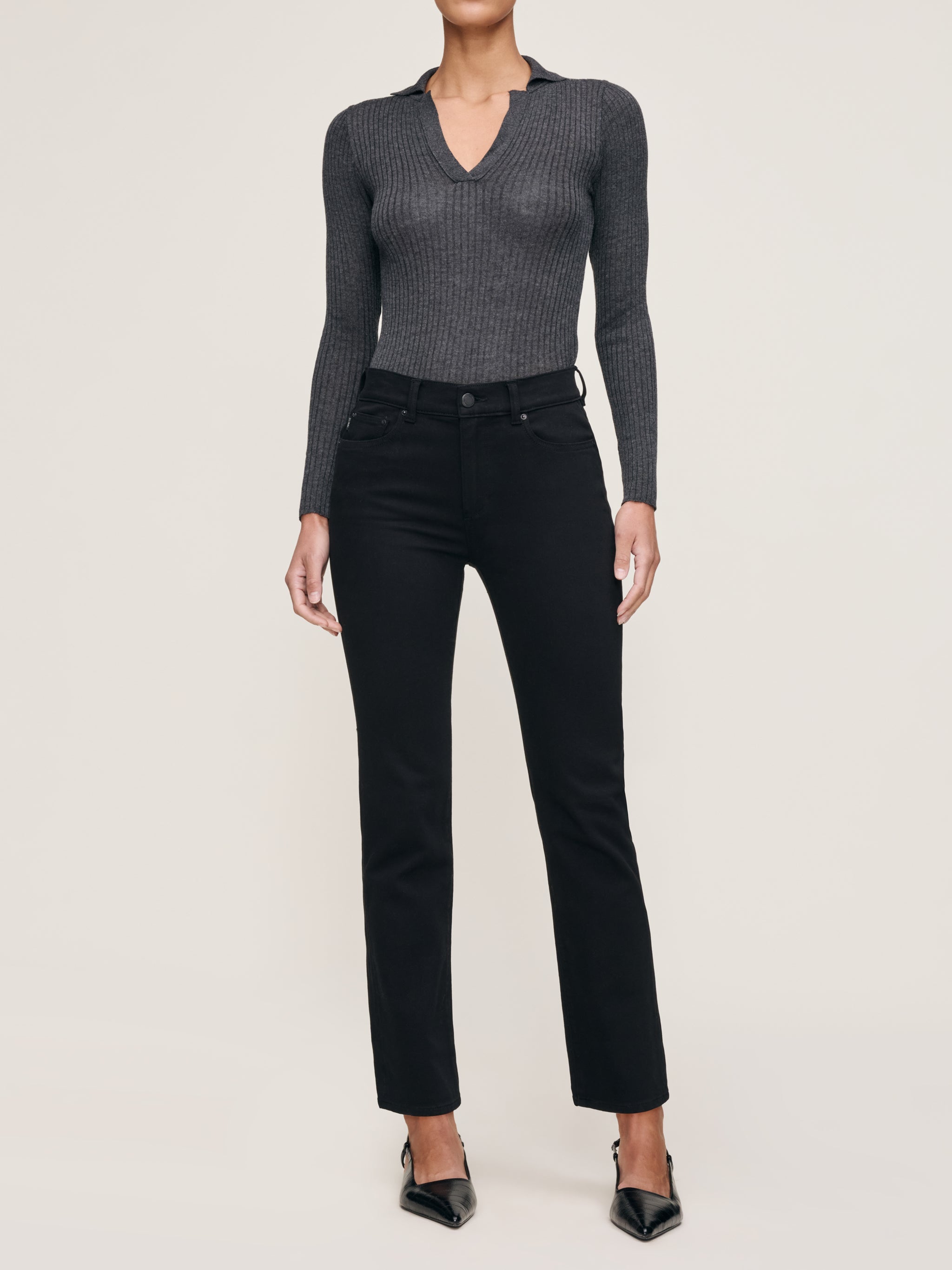 Mara jeans in Black on a model in a grey knit polo, full-length front view in a studio.
