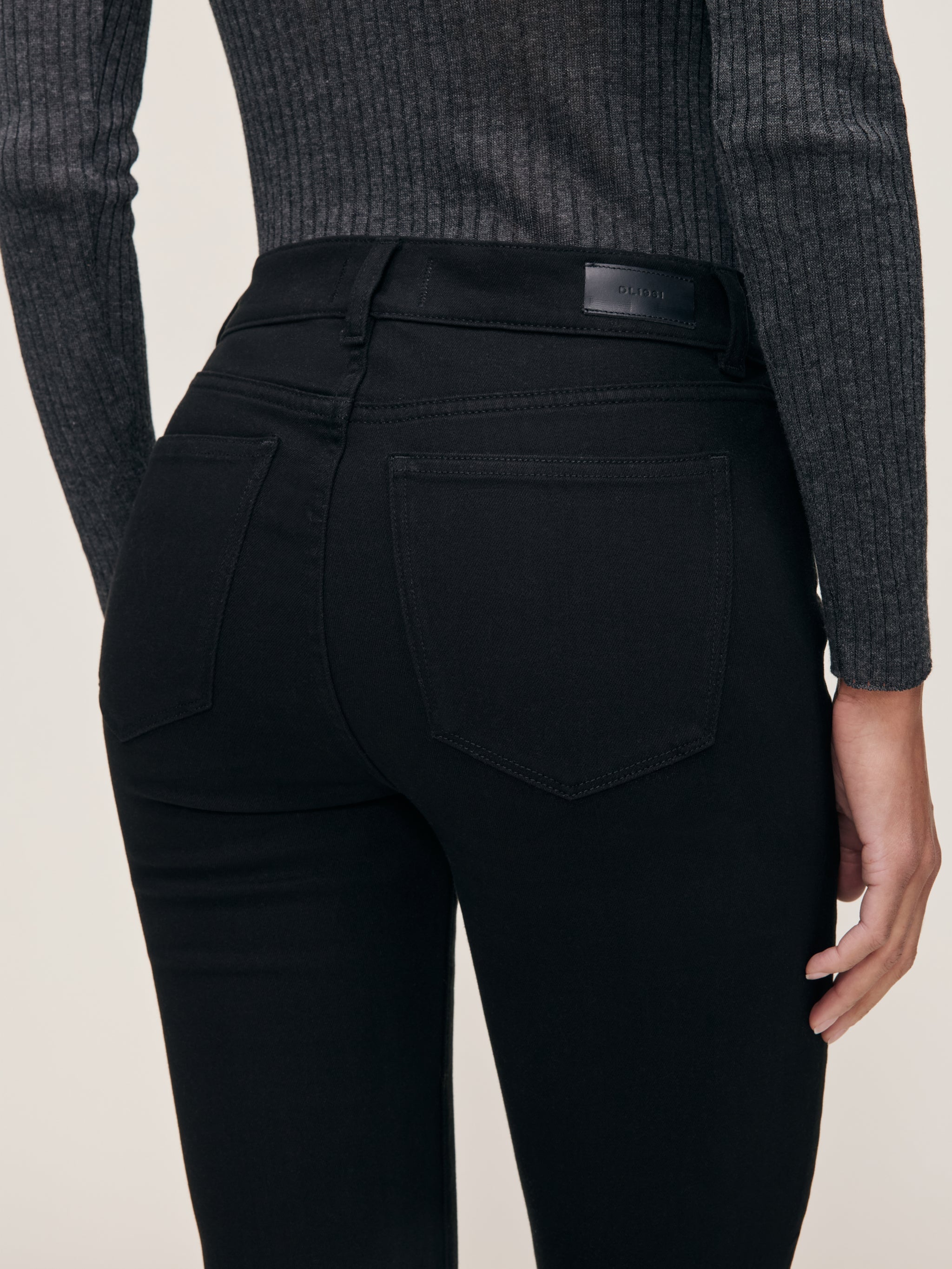 Mara jeans in Black, close-up of the high-rise waist and back pocket on a model.