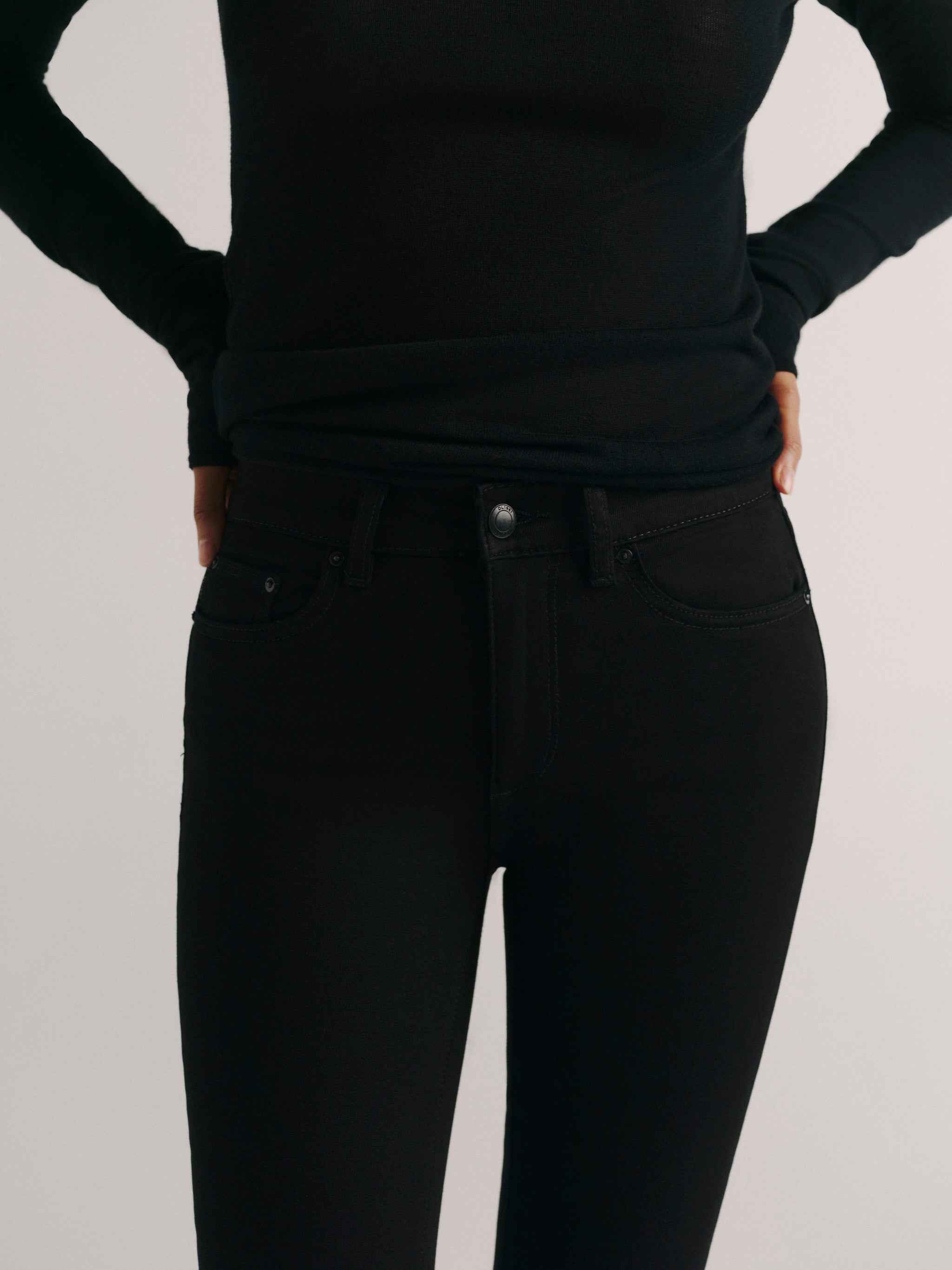DL1961 women's Mara Straight Mid Rise Instasculpt ankle jeans in black, close-up of the mid rise waist, button and front pocket.