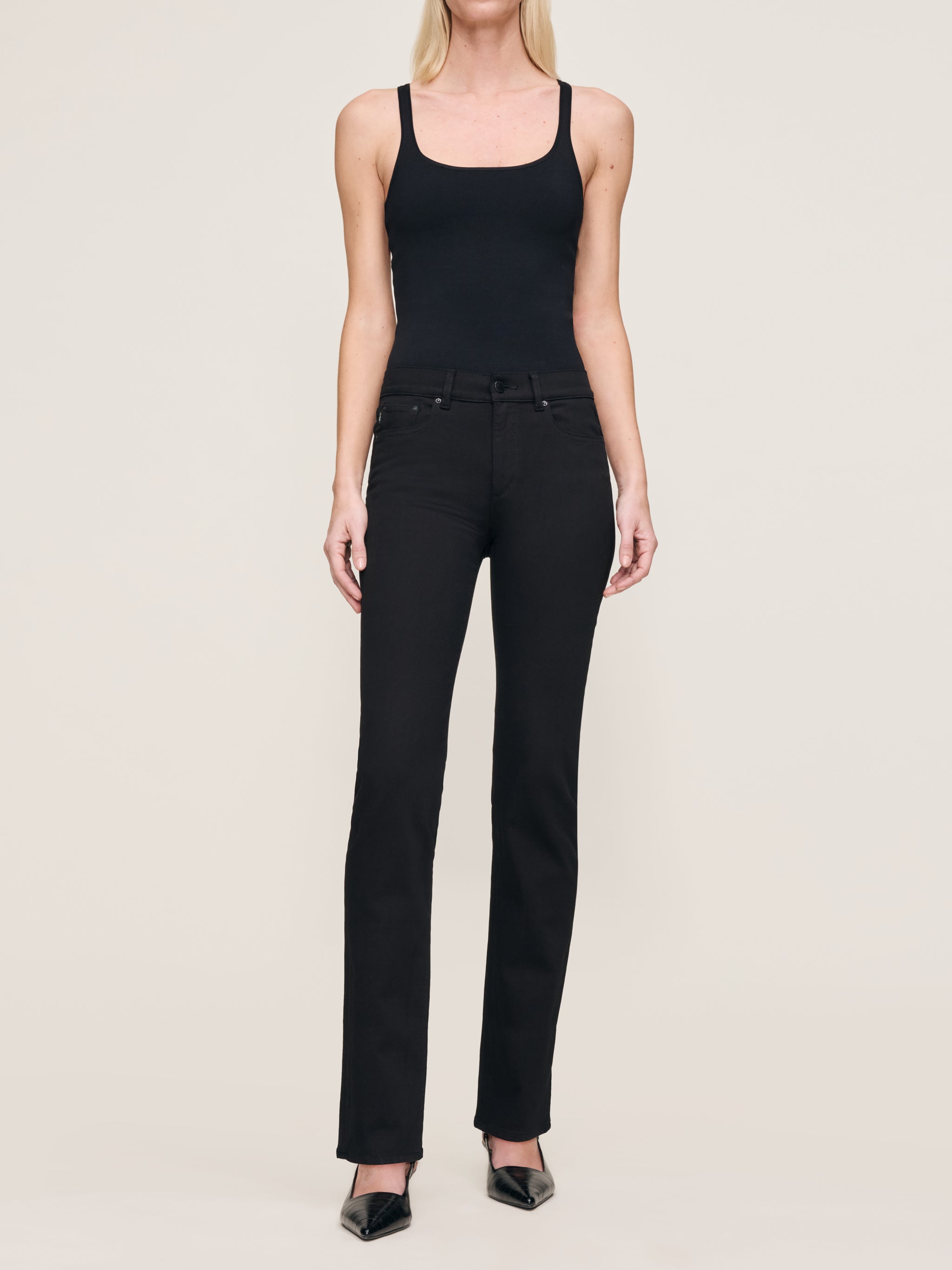 Mara jeans in Black on a model in a black tank, full-length front view in a studio.