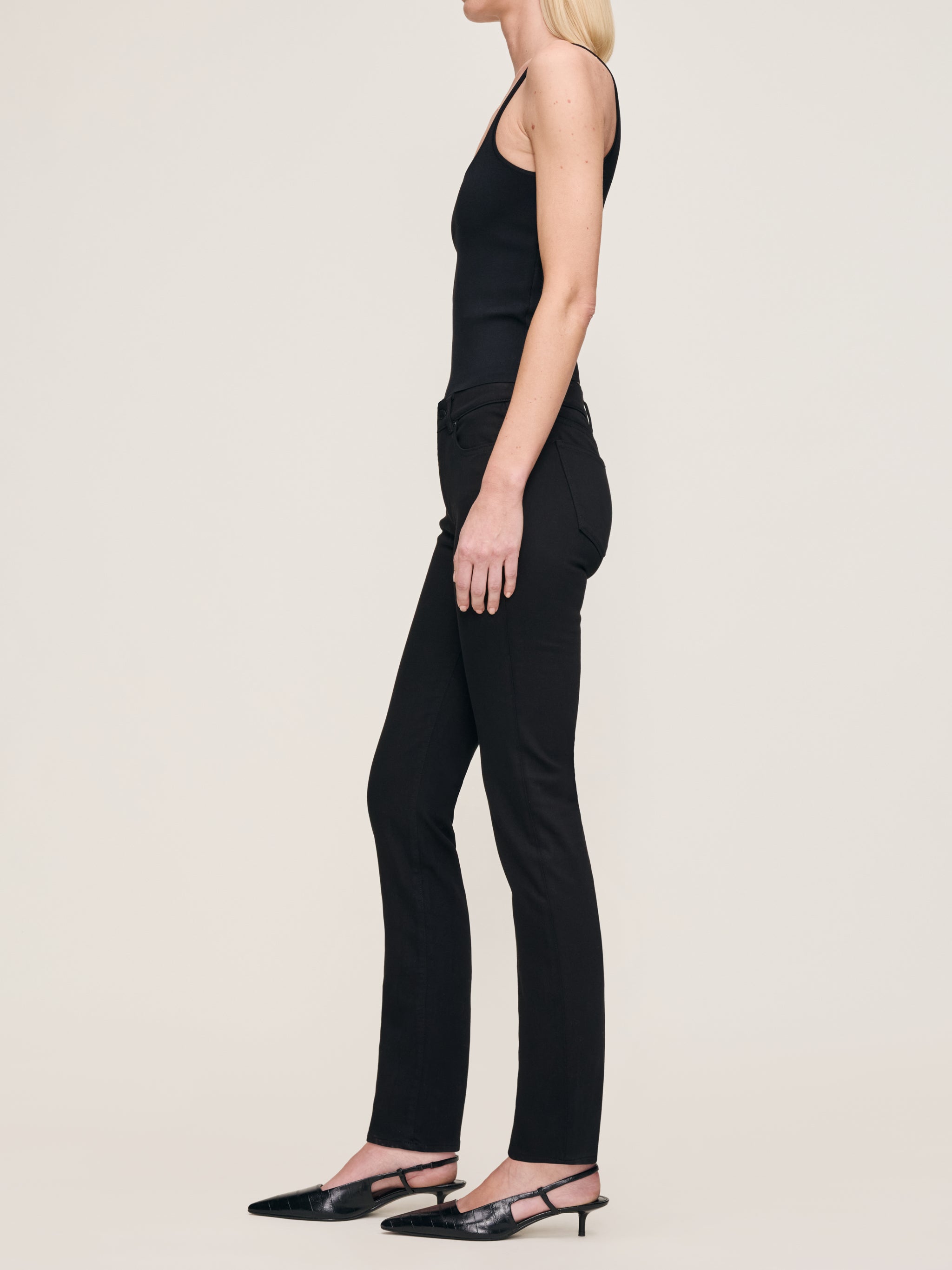 Mara jeans in Black on a model in a black tank, full-length side profile with kitten heels.