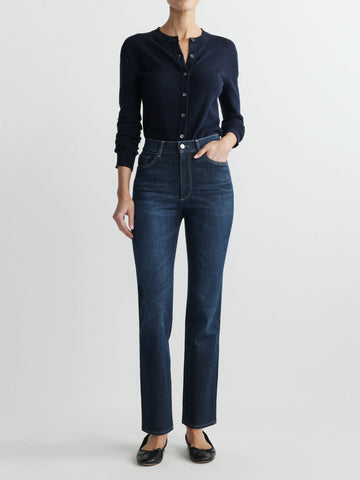 Person wearing a navy button-up shirt and dark blue jeans on a white background