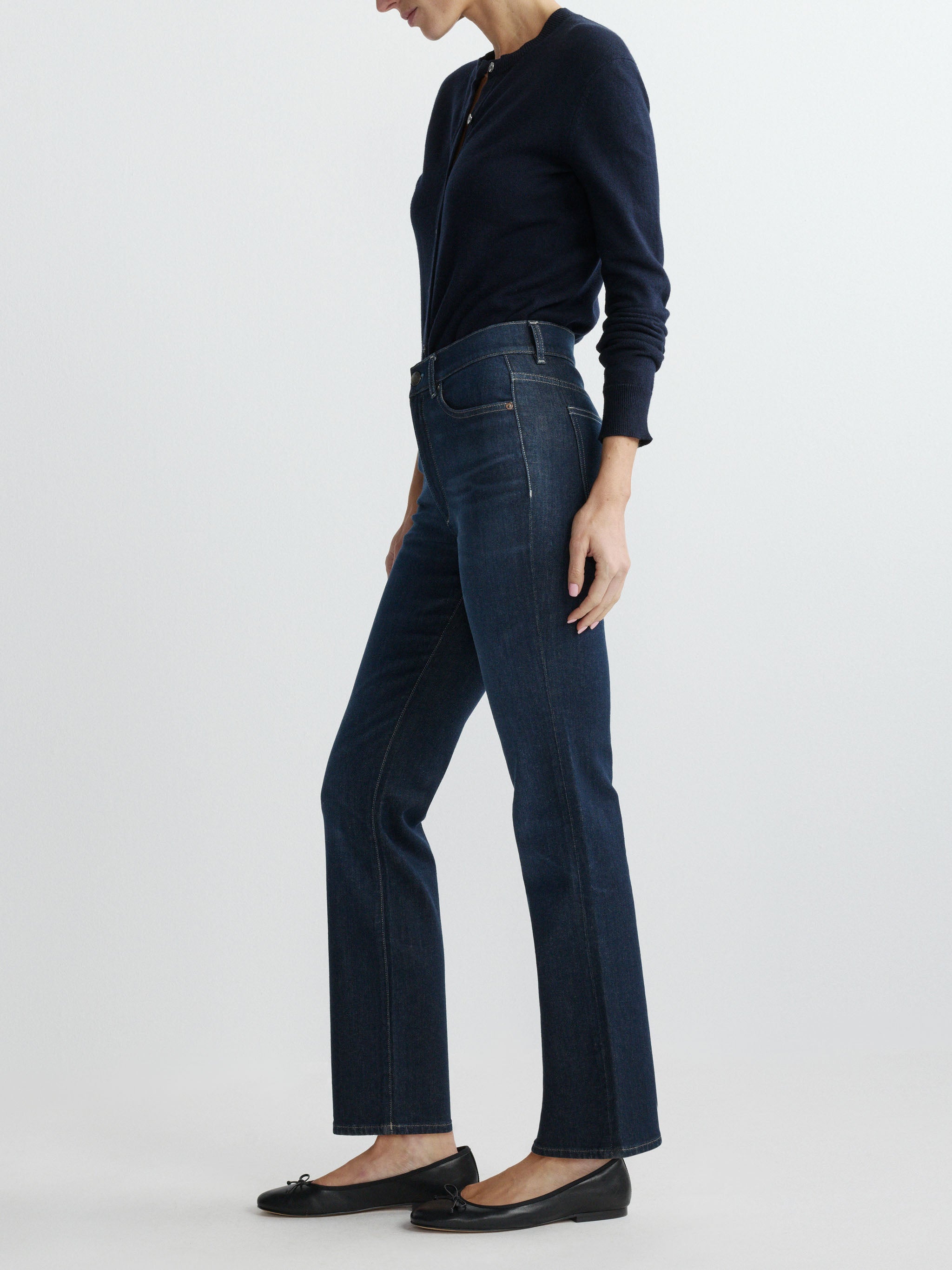 Person wearing dark blue jeans and a matching top on a white background