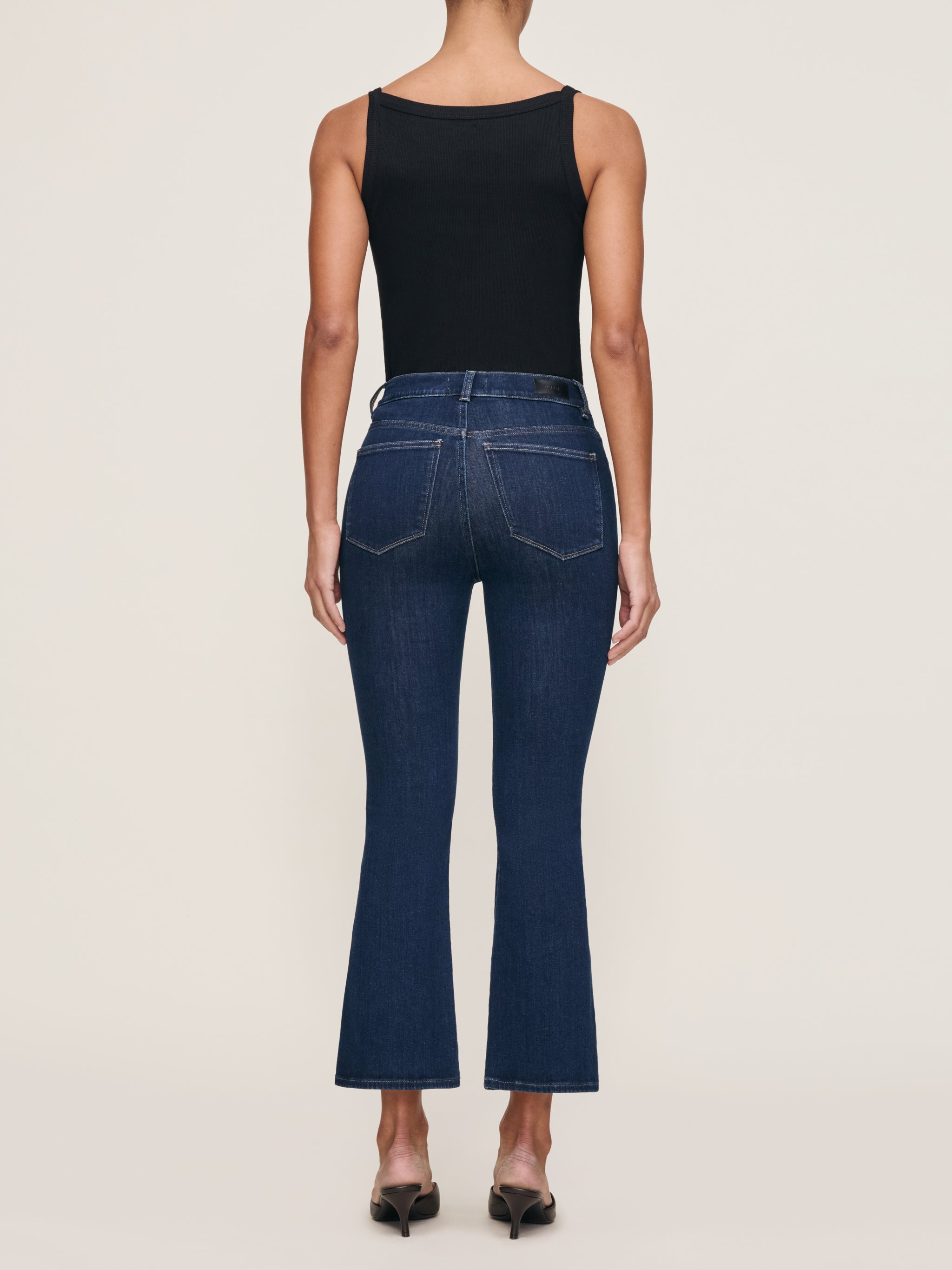 Bridget jeans in Lunar Sky styled with the Ribbed Tank in Black, full-length back view in a studio.