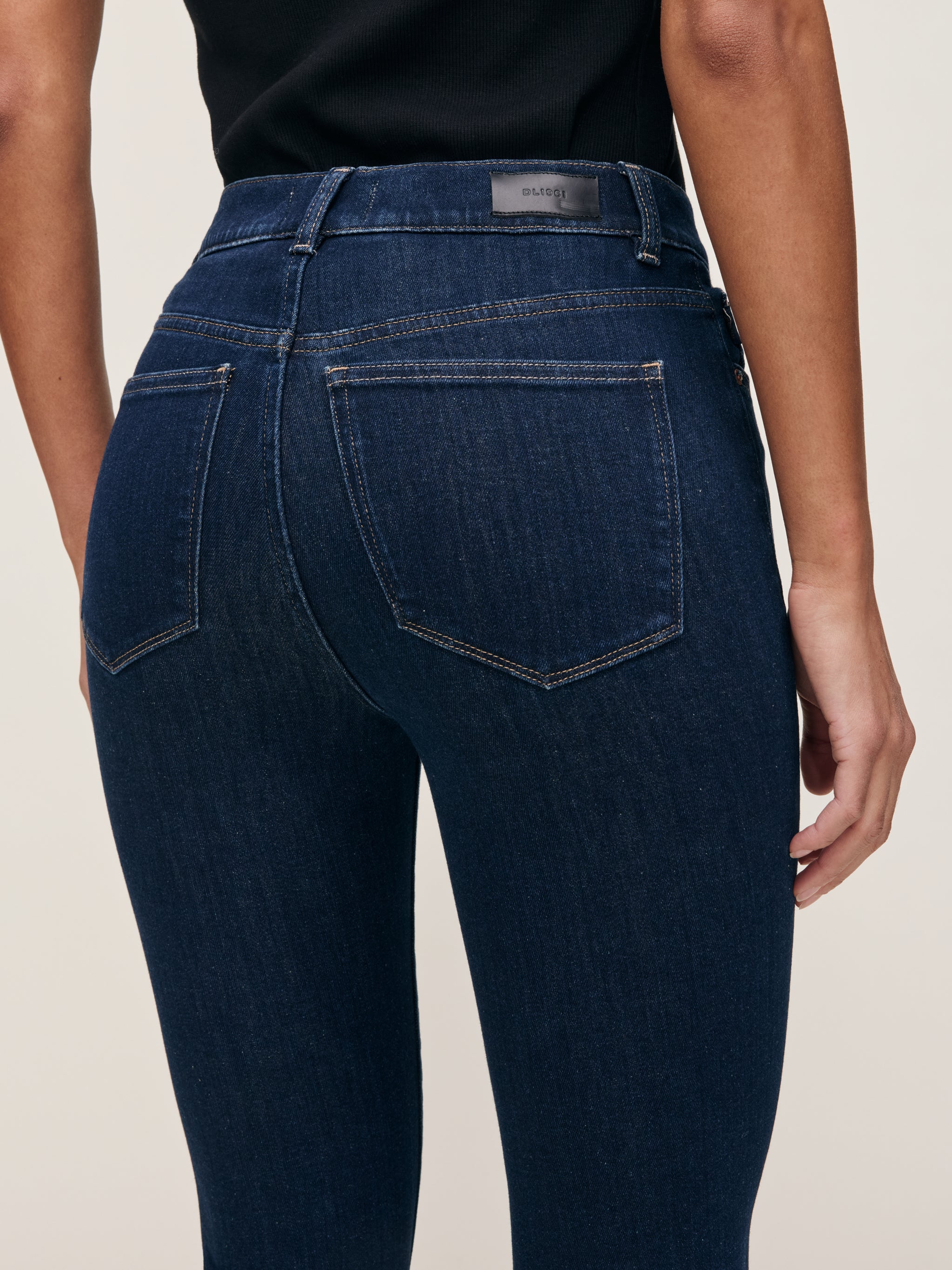Bridget jeans in Lunar Sky on a model, close-up back view of the waist and pockets in a studio.