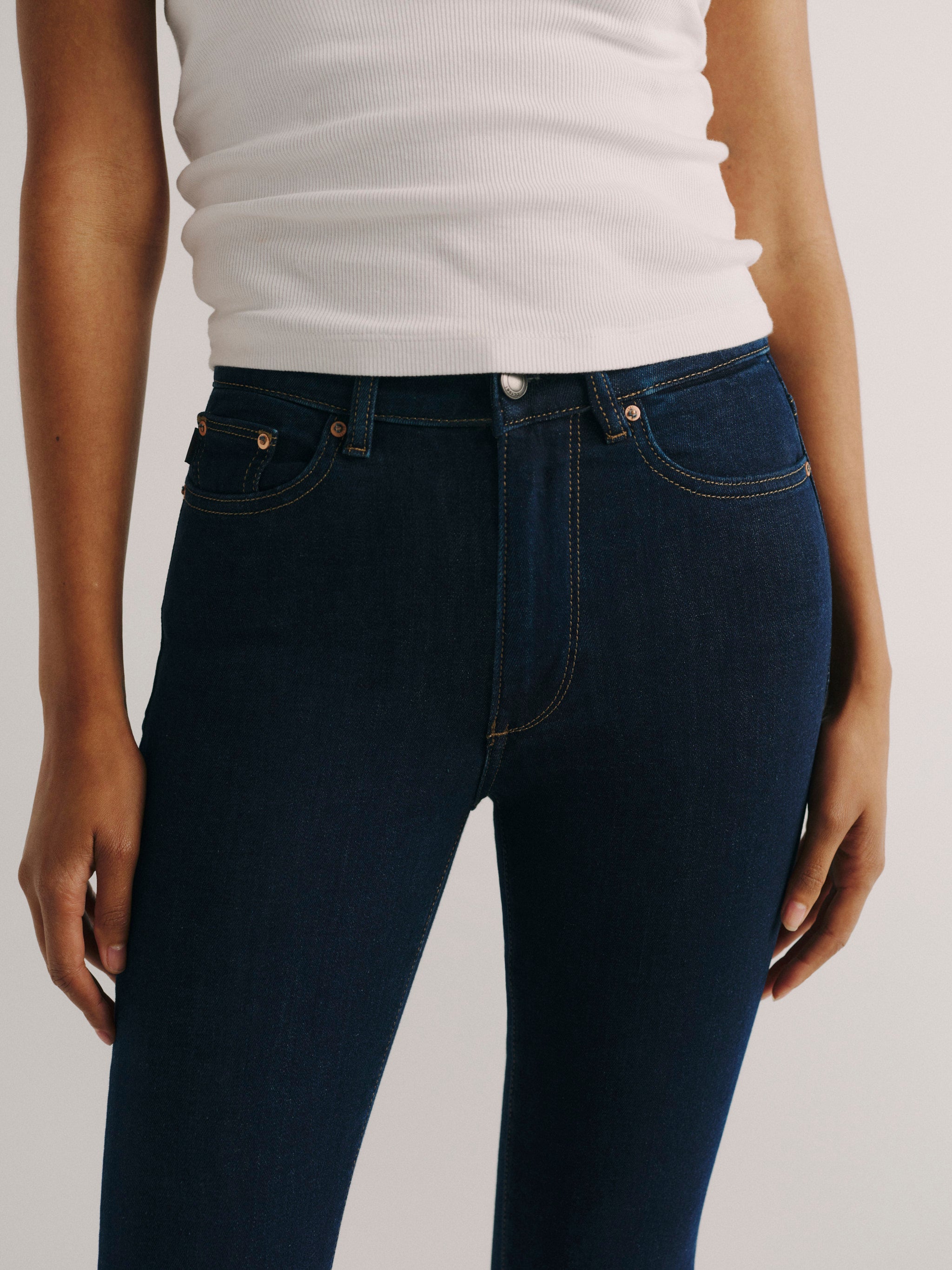 DL1961 women's Bridget Boot High Rise Instasculpt crop jeans in dark indigo 'Lunar Sky', close-up of the high rise waist and front pocket.