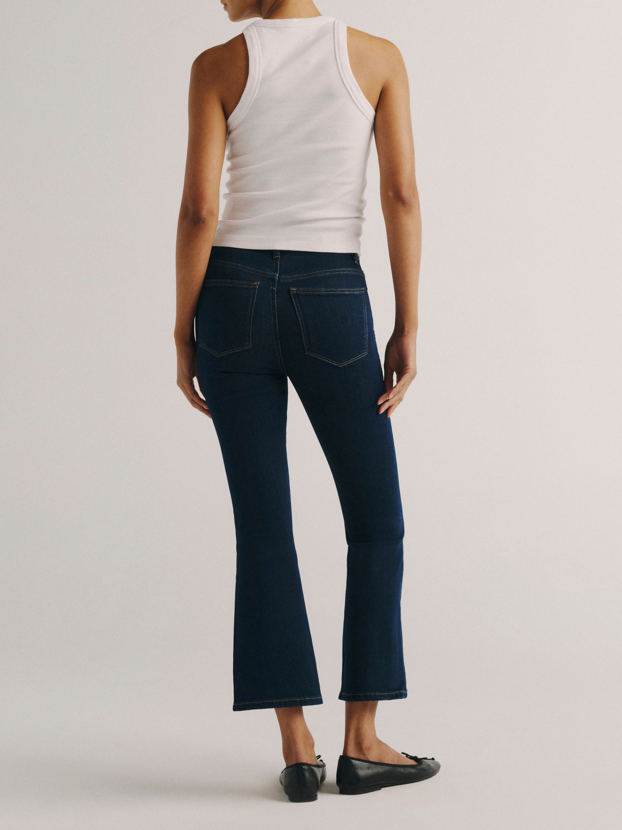 DL1961 women's Bridget Boot High Rise Instasculpt crop jeans in dark indigo 'Lunar Sky', back view showing the rear pockets and cropped leg.