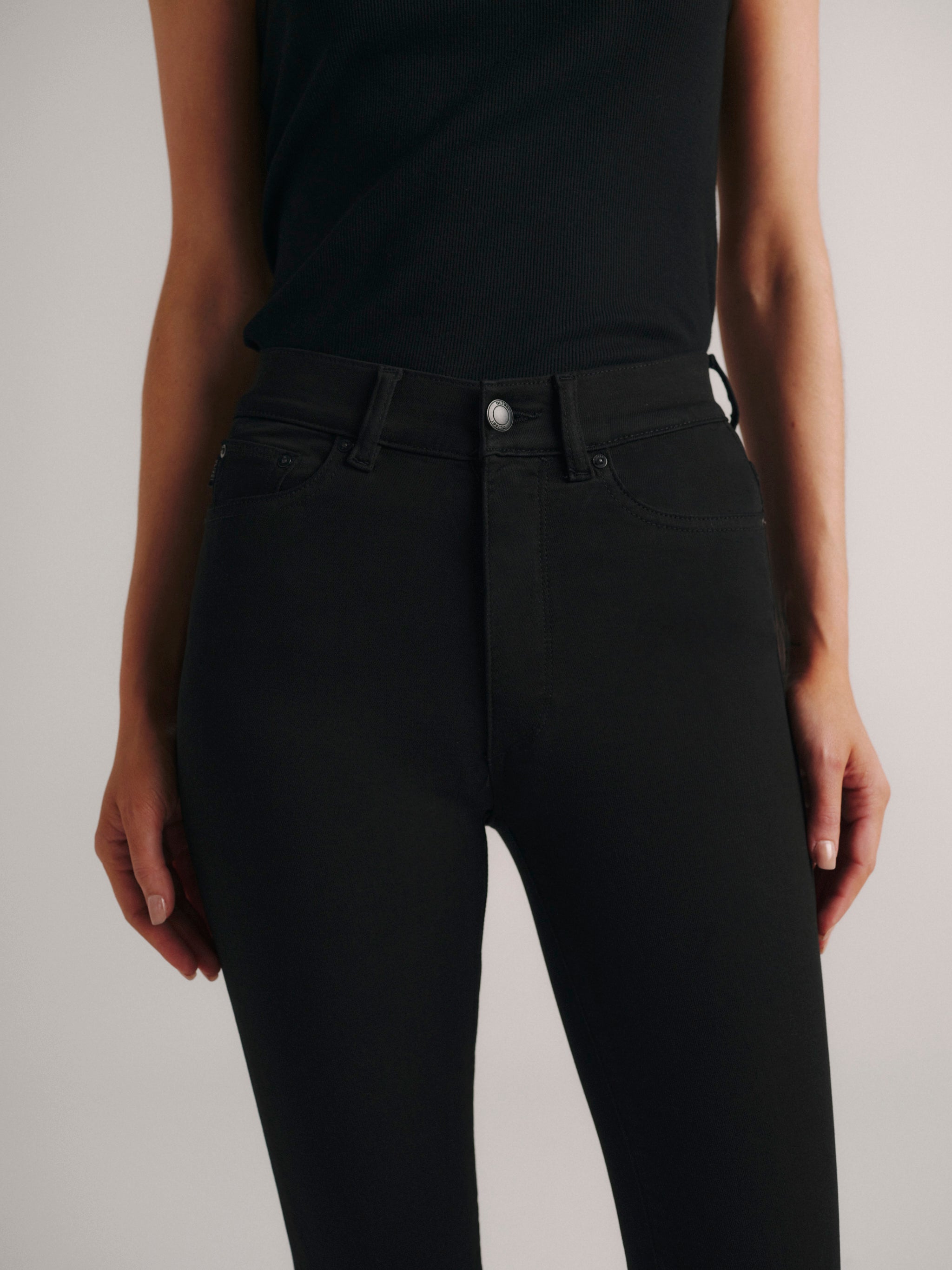 Close-up front detail of DL1961 Bridget Boot cropped jeans in dark 'Hail' wash, high-rise waist and pockets.
