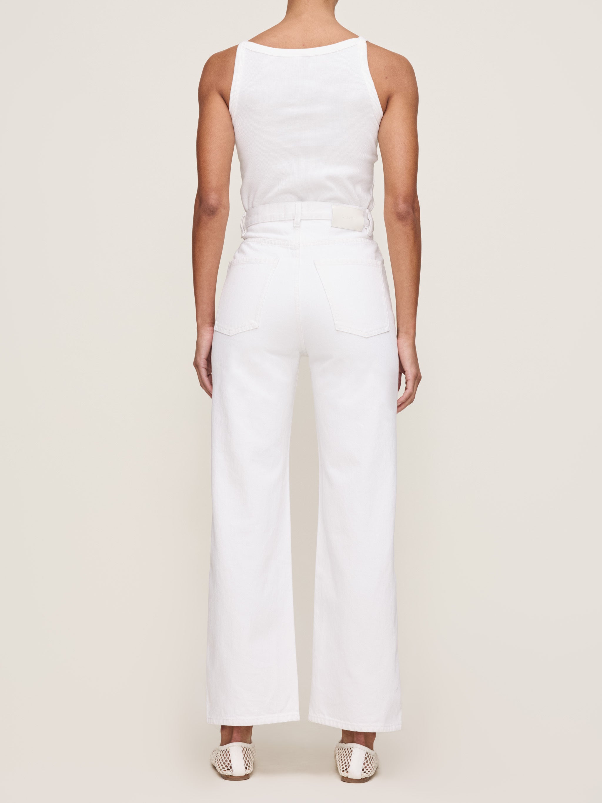 White sleeveless jumpsuit worn by a person on a plain background