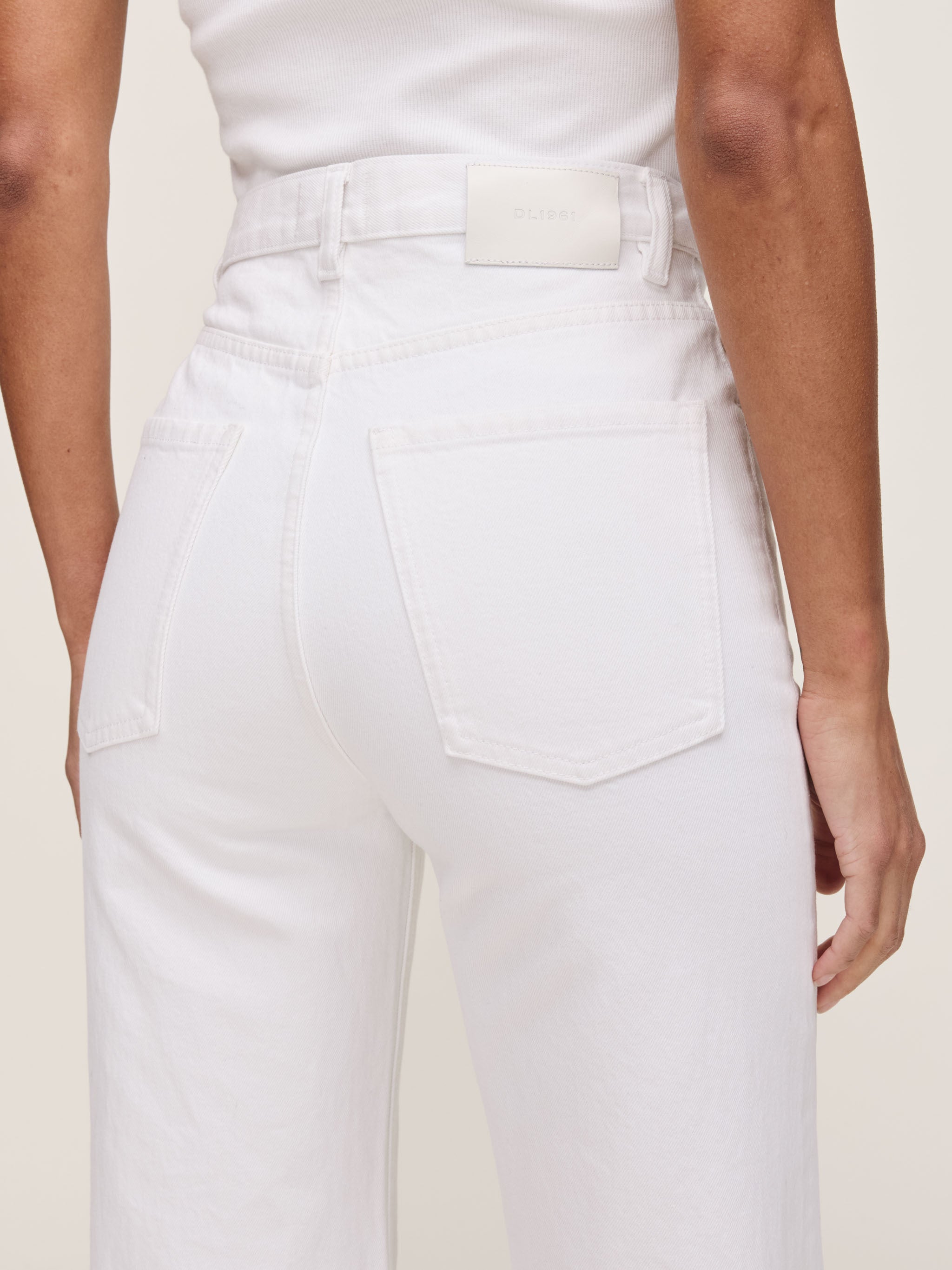 White pants worn by a person on a plain background