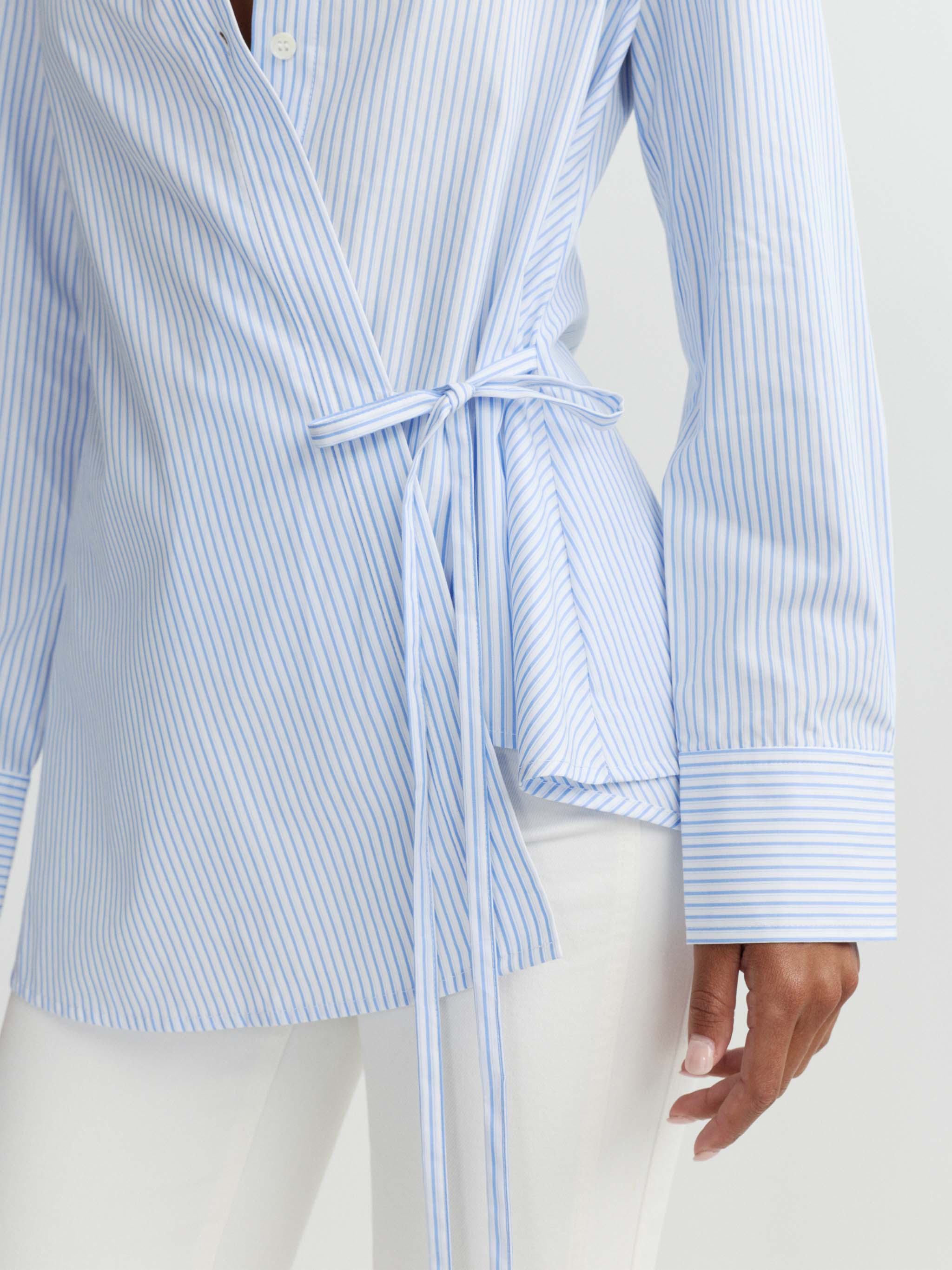 Blue and white striped shirt with a tie detail on a plain background